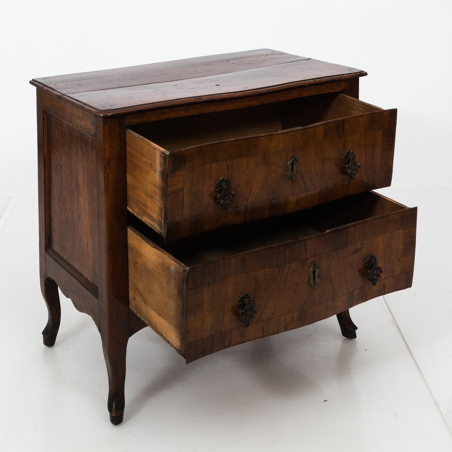 Italian two-drawer chest with metal hardware and cabriole legs, circa 18th century. The wood on the tabletop also features some wear with age and minor contraction in the wood at the center causing a gap.