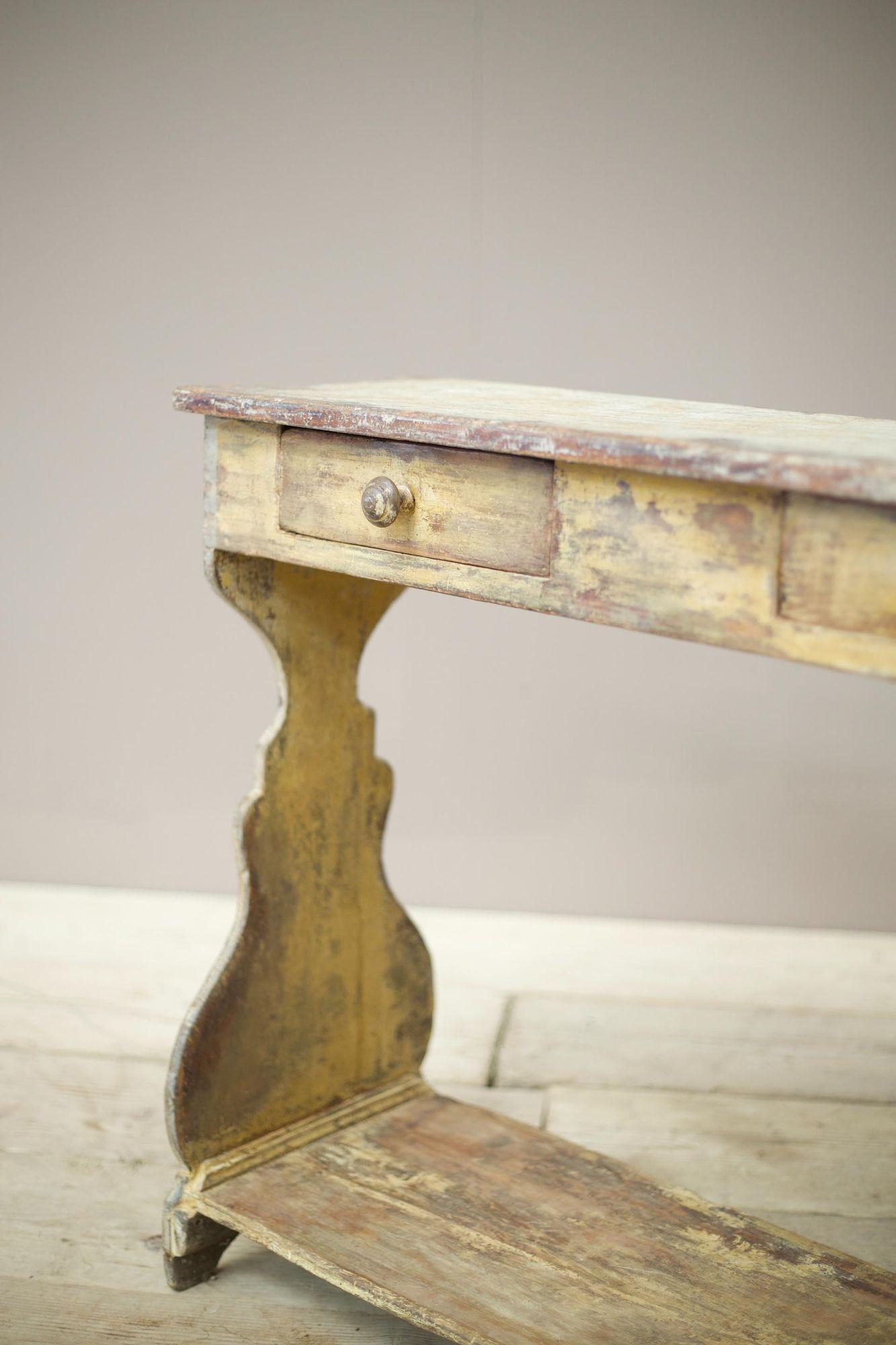 This is a very characterful 18th century Italian occasional table from a Church. The paint looks to be entirely original with the worn lemon yellow which is striking and the faux marble painted top. Solid condition with no major issues and complete