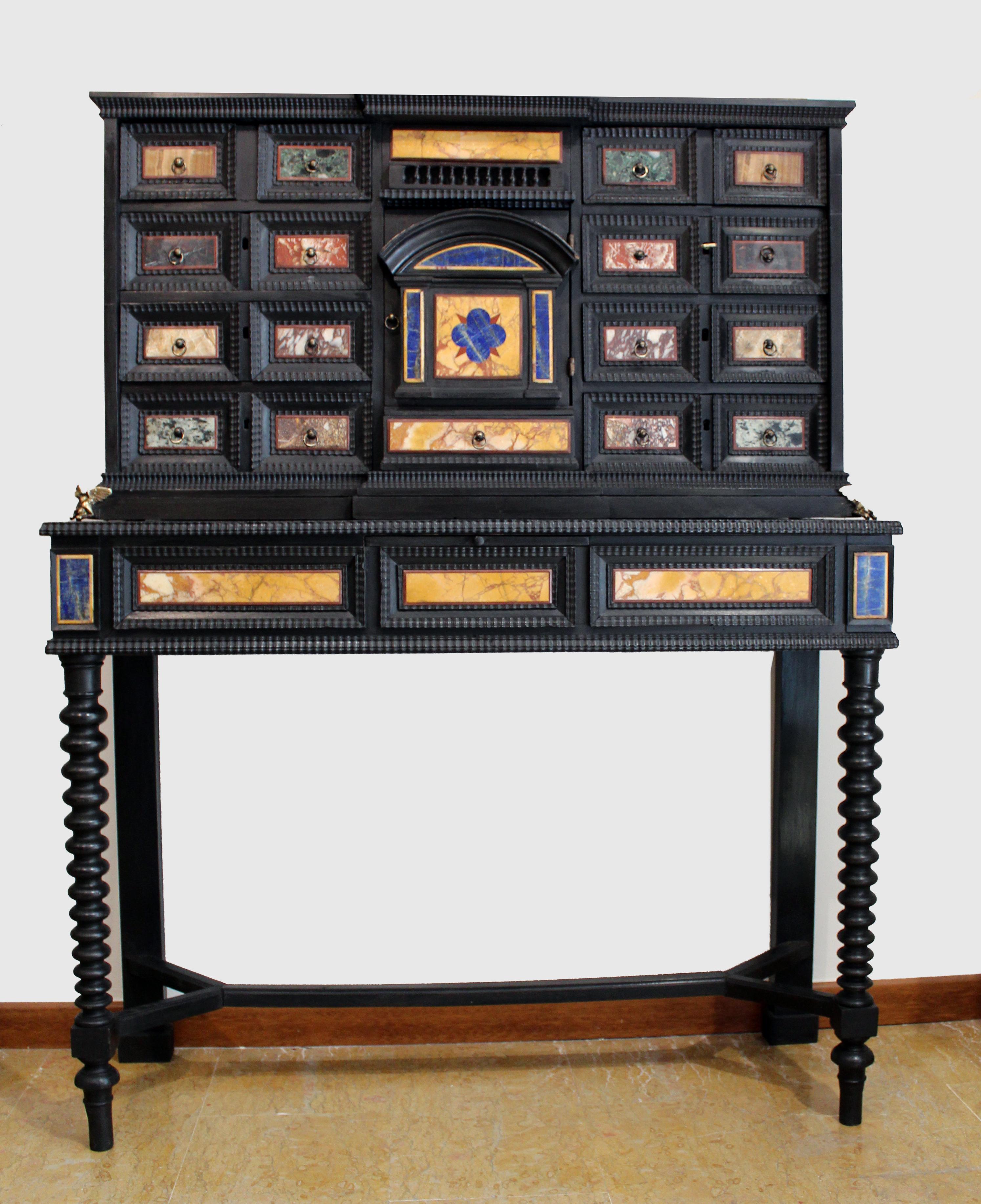 An Italian Classical Roman marble and pietra dura mounted ebony large cabinet on stand
of architectural form and inlaid overall with hardstones including Giallo Antico, Bianco and nero of Aquitania, Alabastro di Busca, lapis lazuli and