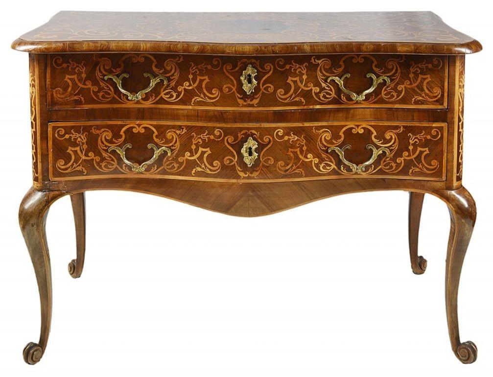 An impressive 18th century Italian Walnut serpentine fronted commode. Having marquetry boxwood inlaid scrolling decoration to the top, sides and drawer fronts, the original brass scroll handles, two full length pine lined drawers, shaped apron to