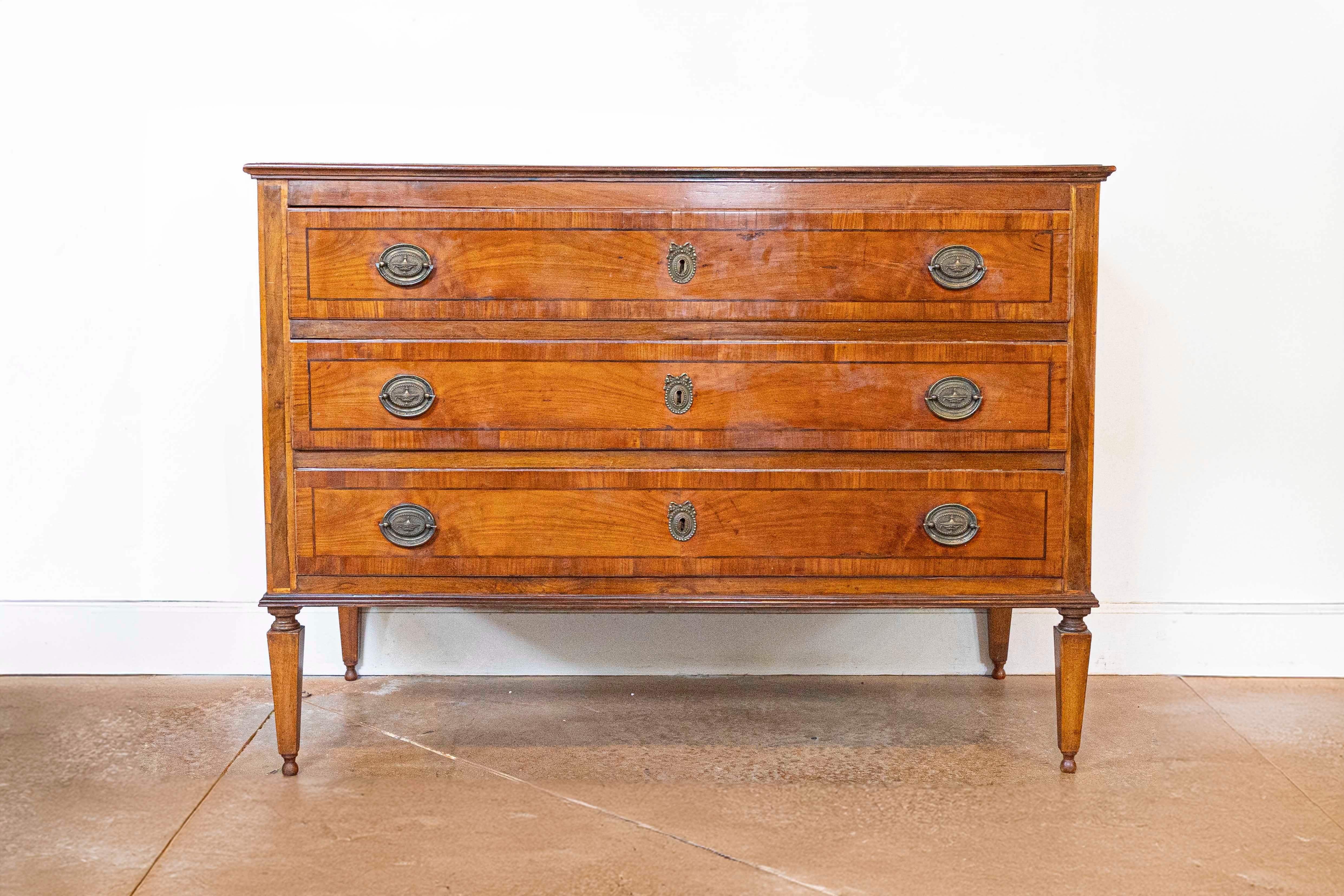 Diese exquisite italienische Kommode aus dem 18. Jahrhundert zeigt die zeitlose Eleganz des neoklassischen Designs und verbindet Form und Funktion mit meisterhafter Handwerkskunst. Die Kommode ist aus reichem Nussbaumholz gefertigt und weist eine