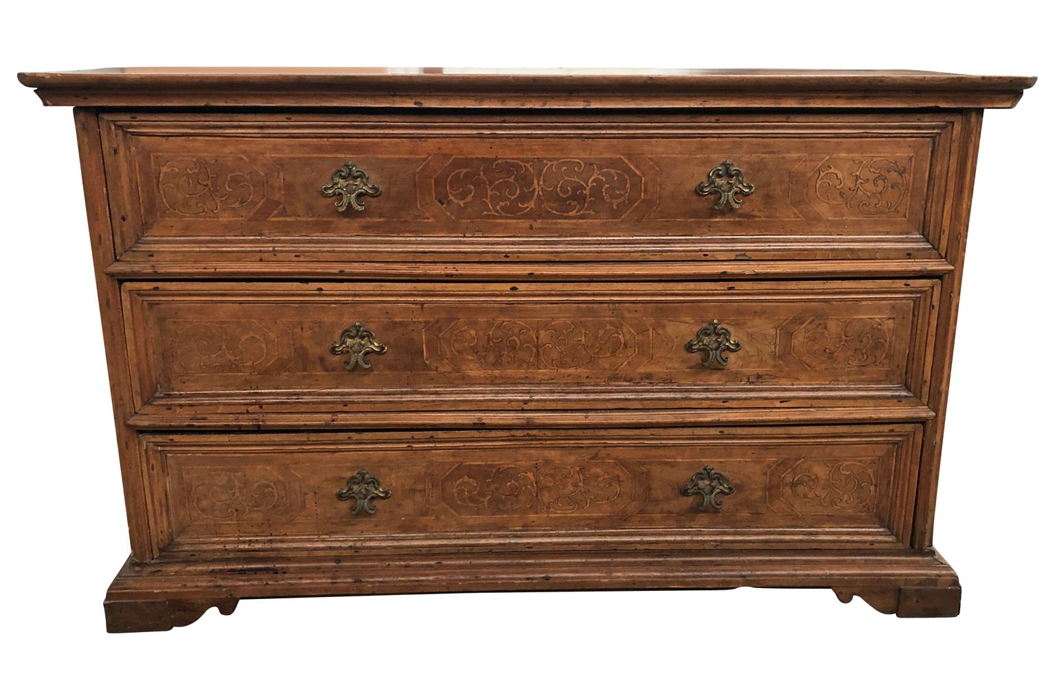 An exceptional 18th century commode from the Lombardi region of Italy. Soundly constructed from stunning walnut with wonderful inlay, three drawers over bracket feet. Outstanding patina, warm and luminous.