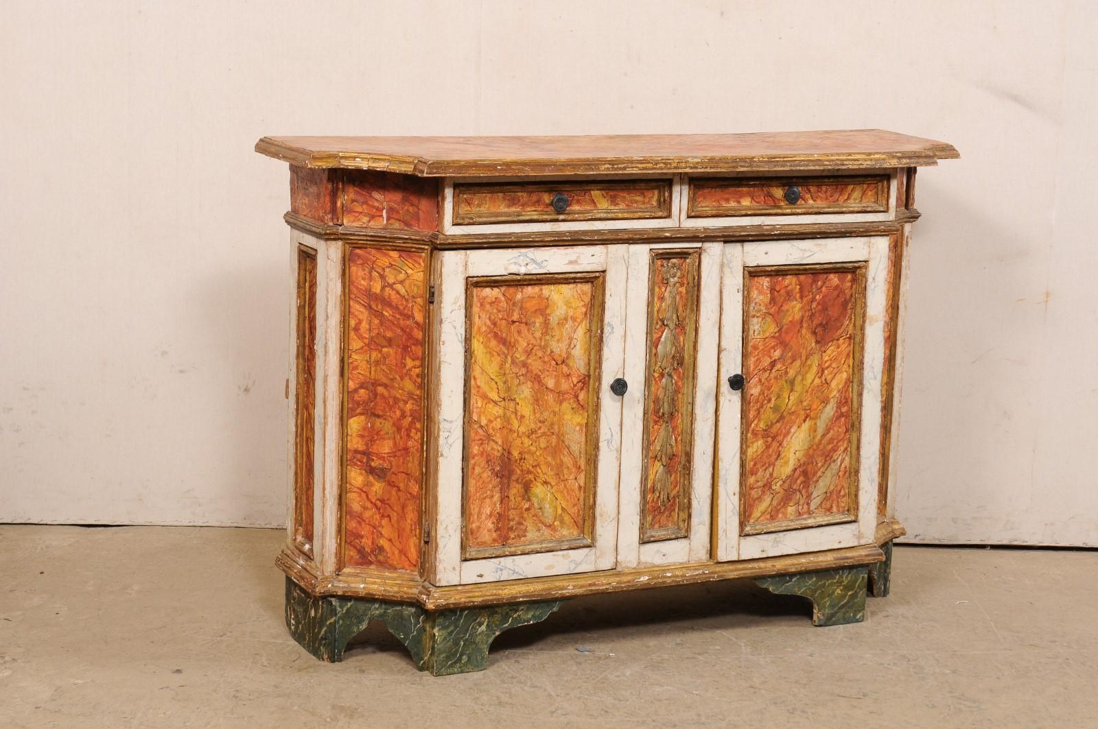 An Italian carved and painted wood credenza from the 18th century. This antique cabinet from Italy has a rectangular-shape, with front corners convexly scalloped inward, giving this piece a lovely shaped. The case houses a pair of smaller sized