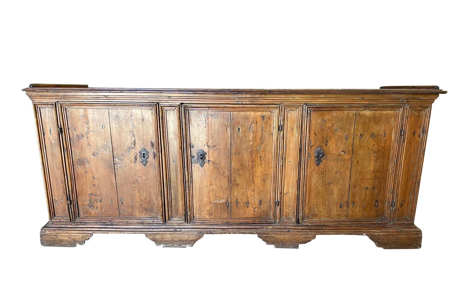 18th century credenza from Northern Italy. Beautifully constructed from richly stained pine with 3 doors, interior shelving raised on bracket feet. There is a 