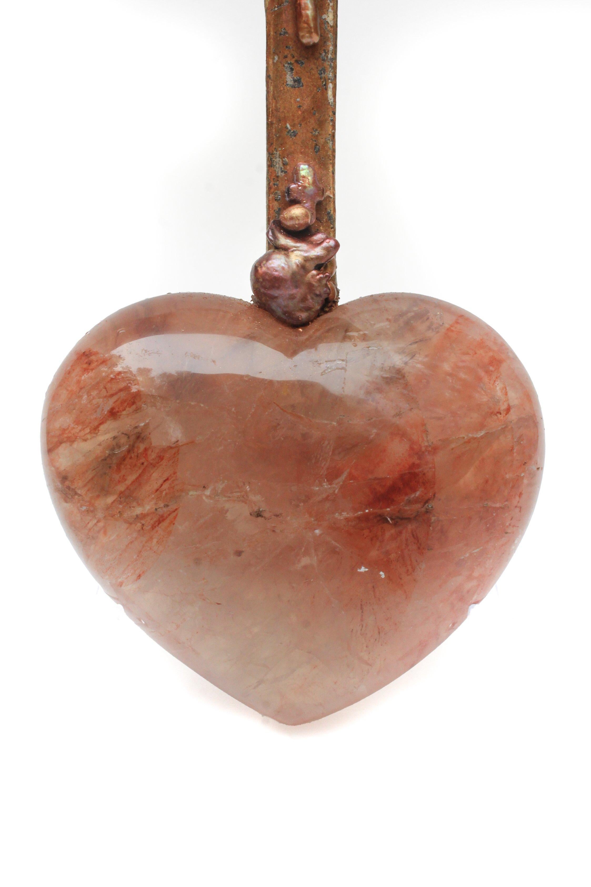 Cruz italiana del siglo XVIII montada sobre un corazón de cuarzo hematoide rojo pulido y adornada con perlas barrocas de forma natural y una perla barroca en forma de cruz. La pieza se inspira en 