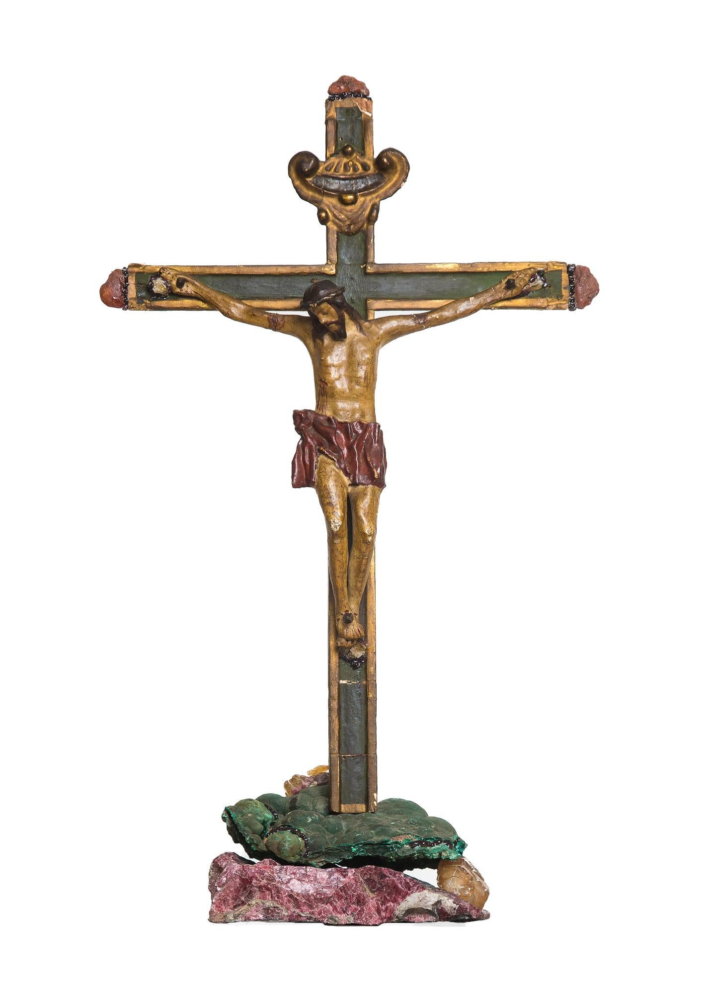 Crucifix italien du 18e siècle monté sur malachite verte, calcite avec fluorine et grenat framboise. La pièce est ornée de galets de cornaline et de grenat. Les minéraux proviennent du monde entier : la malachite verte vient du Congo, le cristal de