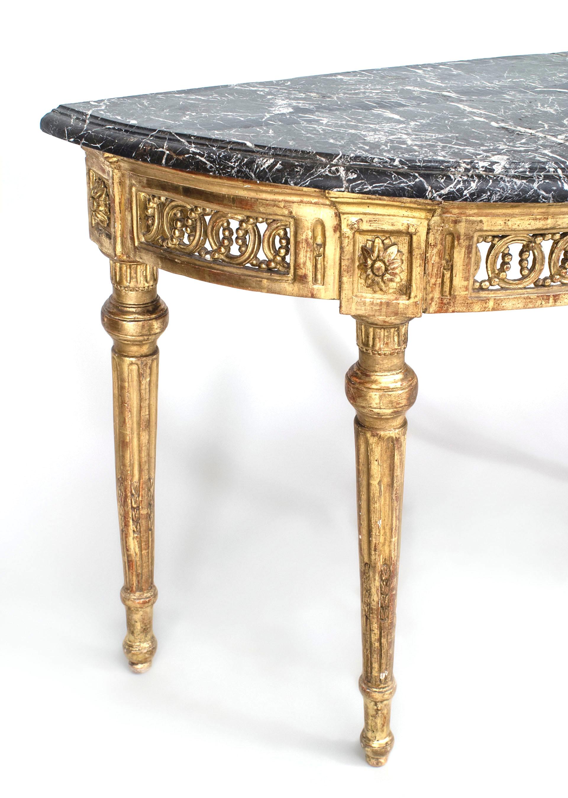 Italian Neo-classic-style (18th Century) gilt demilune shaped console table with fluted tapered legs supporting a filigree apron with a fluted center panel under a black marble top.
