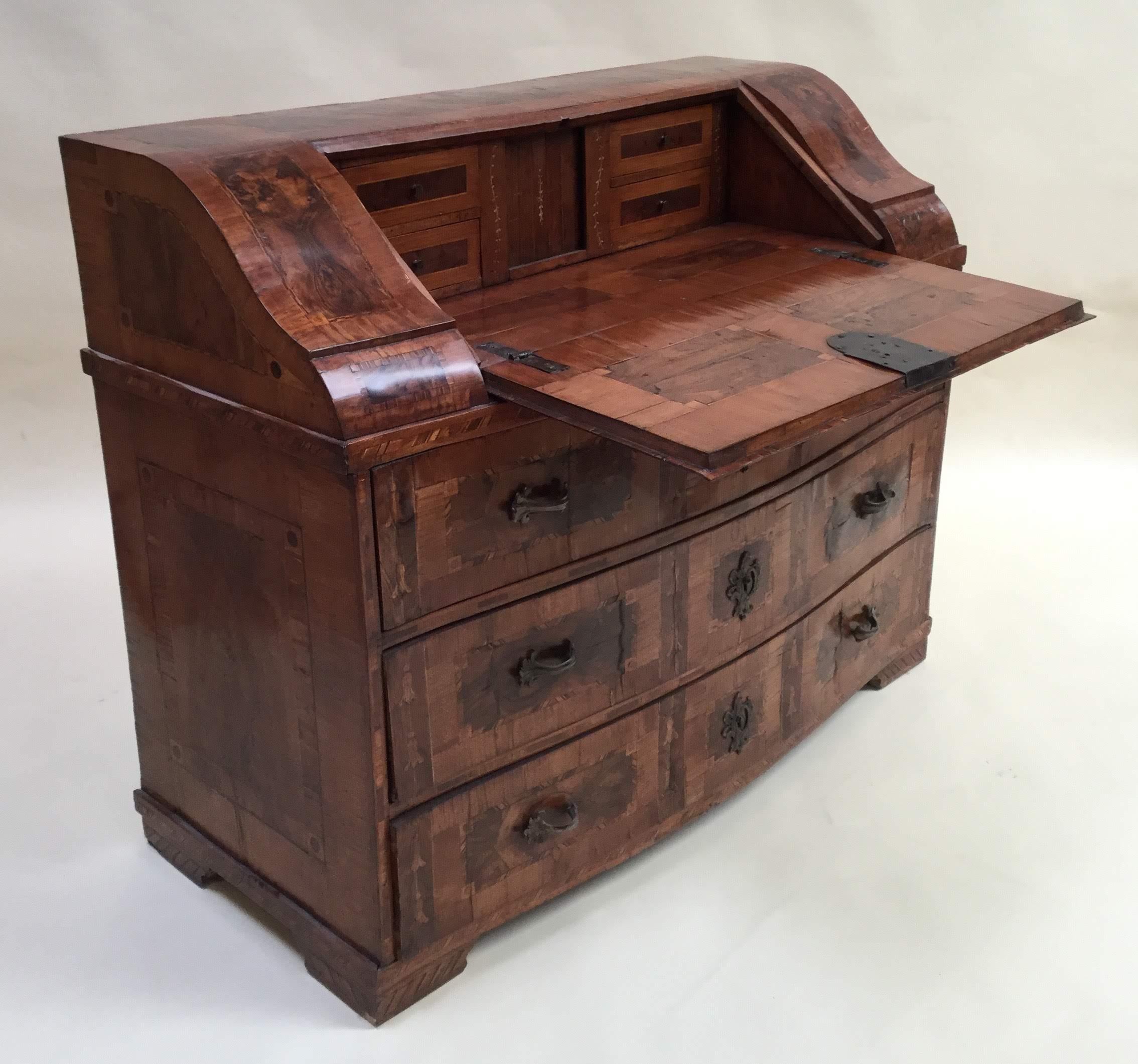 Italian walnut desk with olivewood book match veneering and marquetry inlay.
The upper section with a slatted front, fitted interior, four small drawers and central compartment underneath writing surface. The lower section with three long drawers,