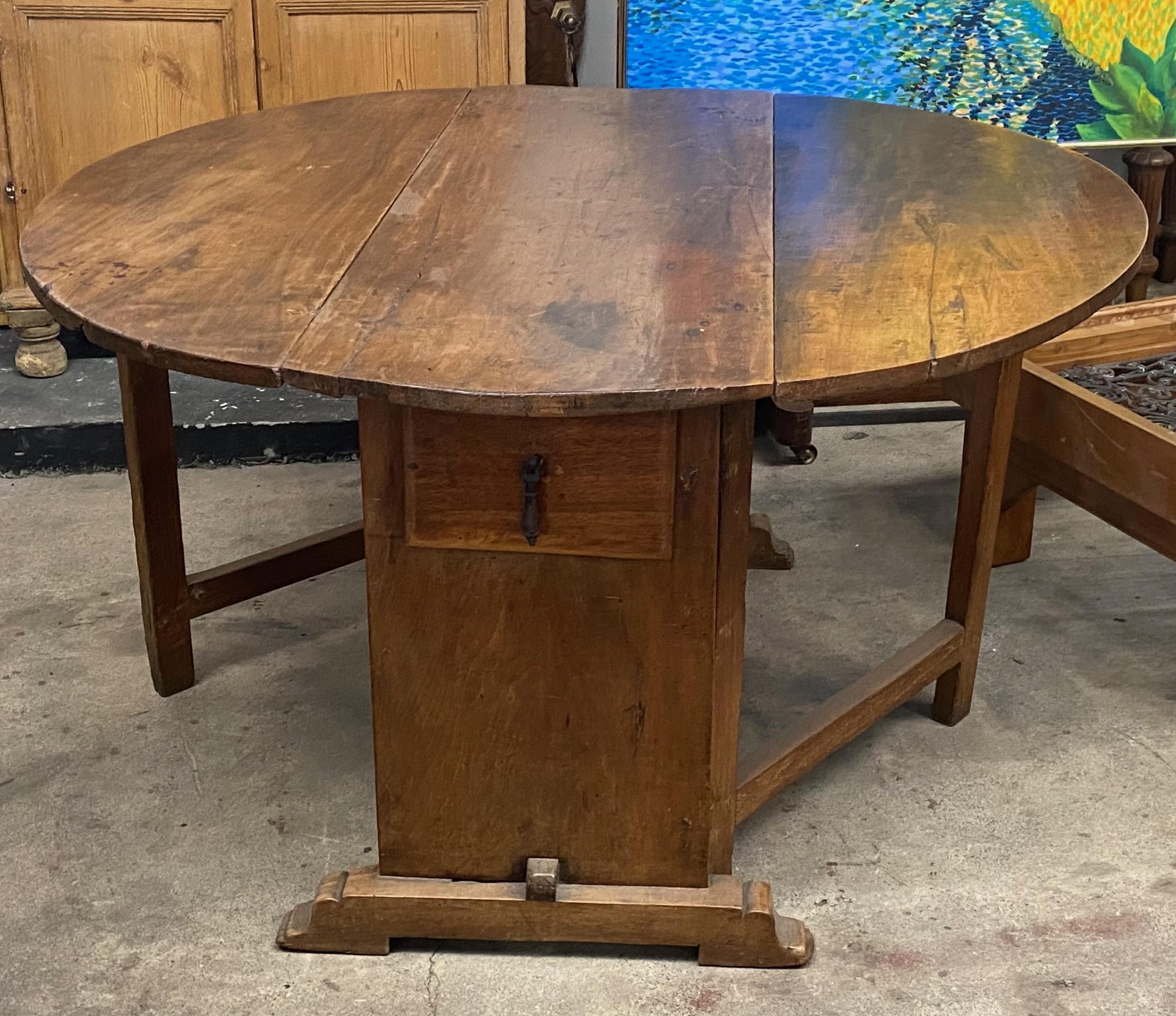 Beautifully aged large solid walnut round drop leaf table.
The gate legs that support the leaves may possibly be old replacements, otherwise in remarkable original condition with original finish.
When the leaves are down the width is 21