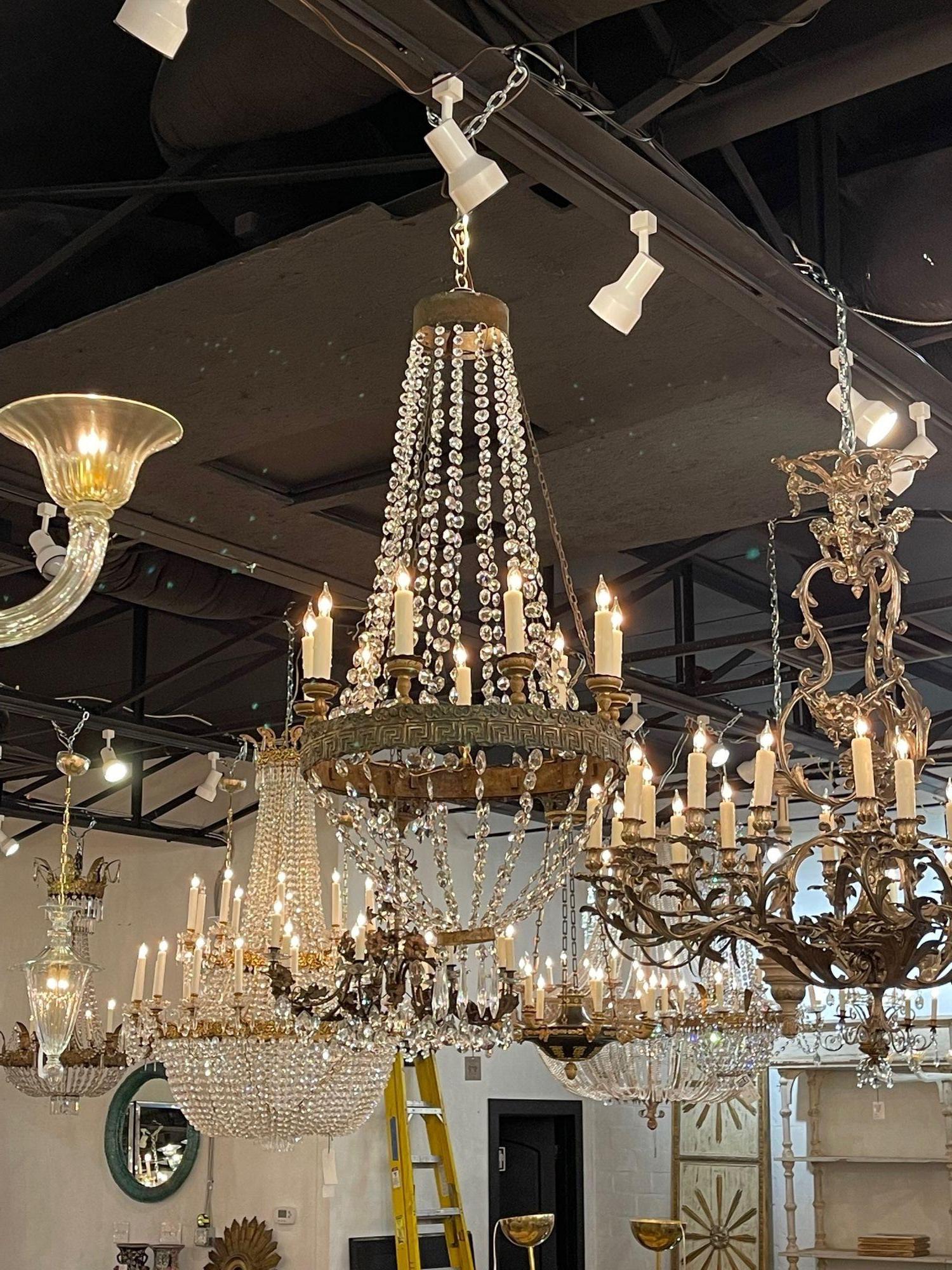 Exceptional 18th century Italian Empire style Brass and crystal basket style chandelier. Featuring glistening crystals and a repousse' Greek key design around the base. Stunning!!