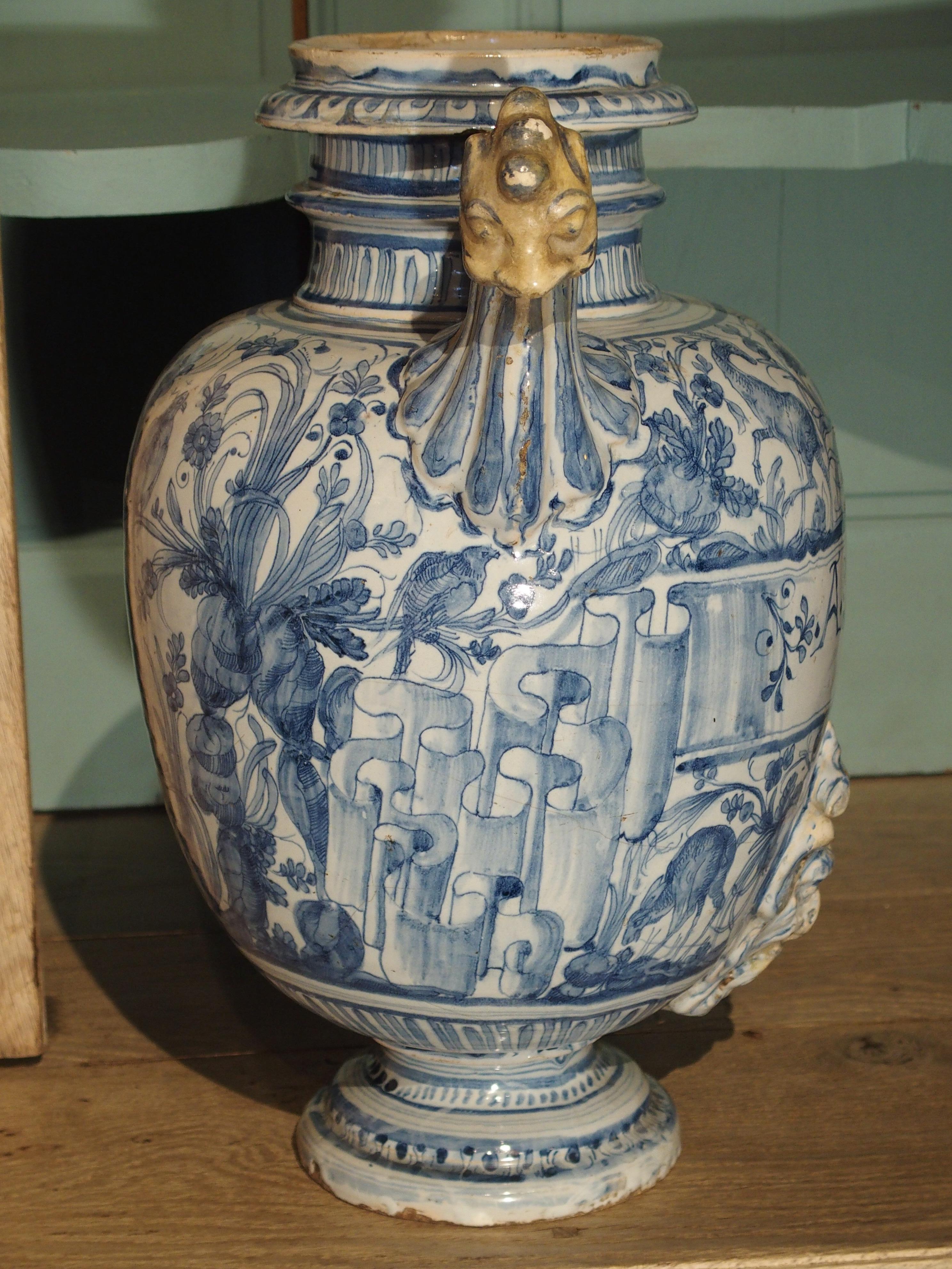 This rare antique vase was originally a fountain body which dispensed the liquid from the the large mascaron face at the bottom center. The blue star marking on the bottom tell us it's originally from the Northwestern Italian region of Liguria,