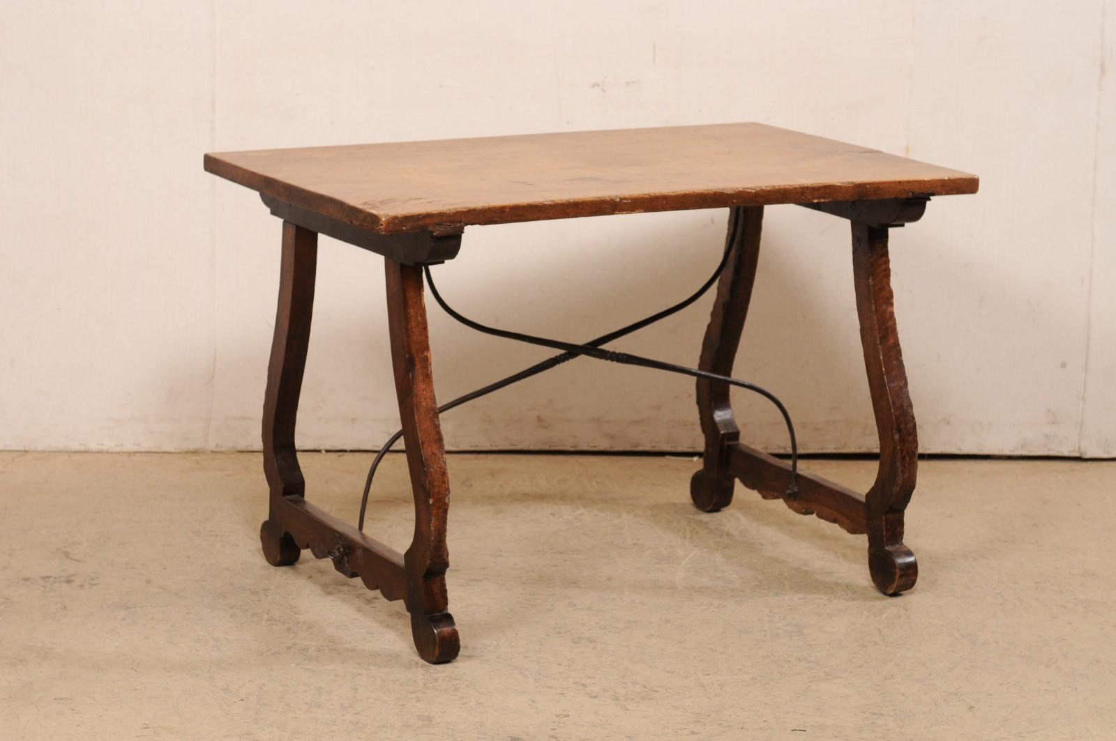 An Italian fratino desk with lyre legs and iron stretcher from the 18th century. This antique table from Italy, in typical fratino style, features a rectangular-shaped wood top raised upon a pair of lyre carved trestle legs, which are braced at the