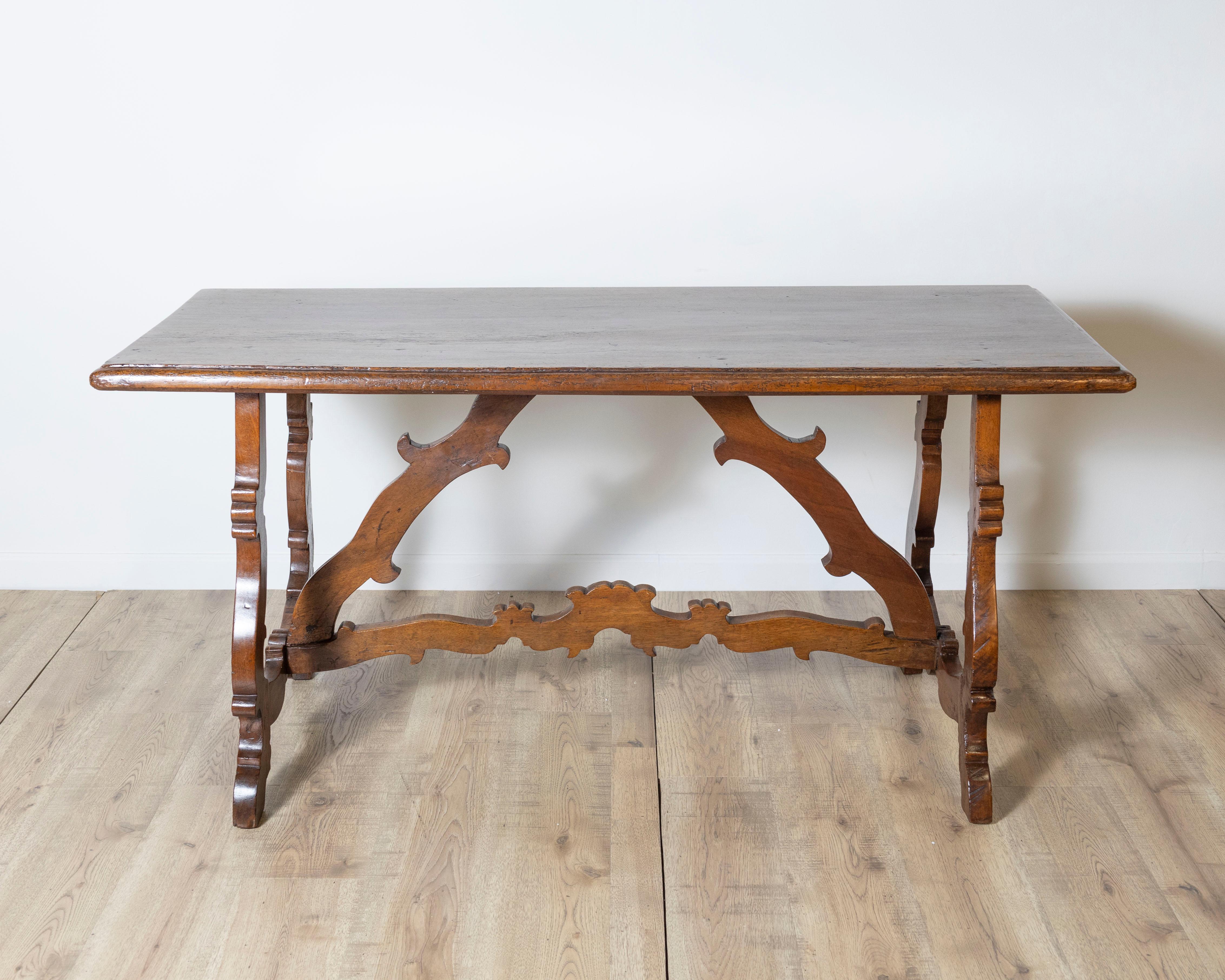 Exemple remarquable de l'artisanat italien du XVIIIe siècle, cette table Fratino est fabriquée en noyer massif richement patiné et comporte des détails sculptés complexes. Le design présente un long plateau rectangulaire soutenu par des pieds