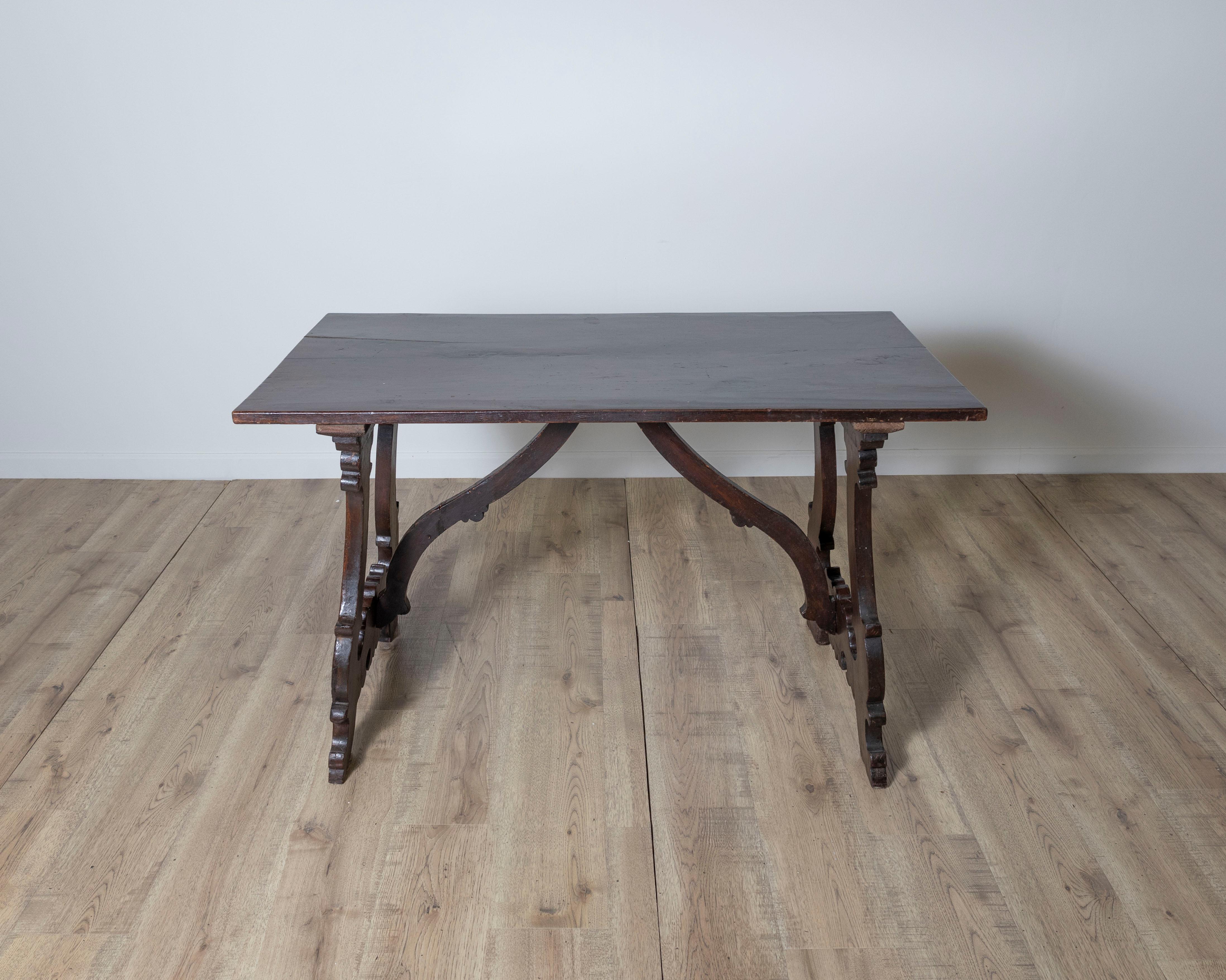 Elegant and timeless, this 18th-century Italian Fratino walnut table embodies the rustic sophistication of ecclesiastical furniture from the period. Crafted in solid walnut, it features a rectangular top supported by boldly carved trestle legs