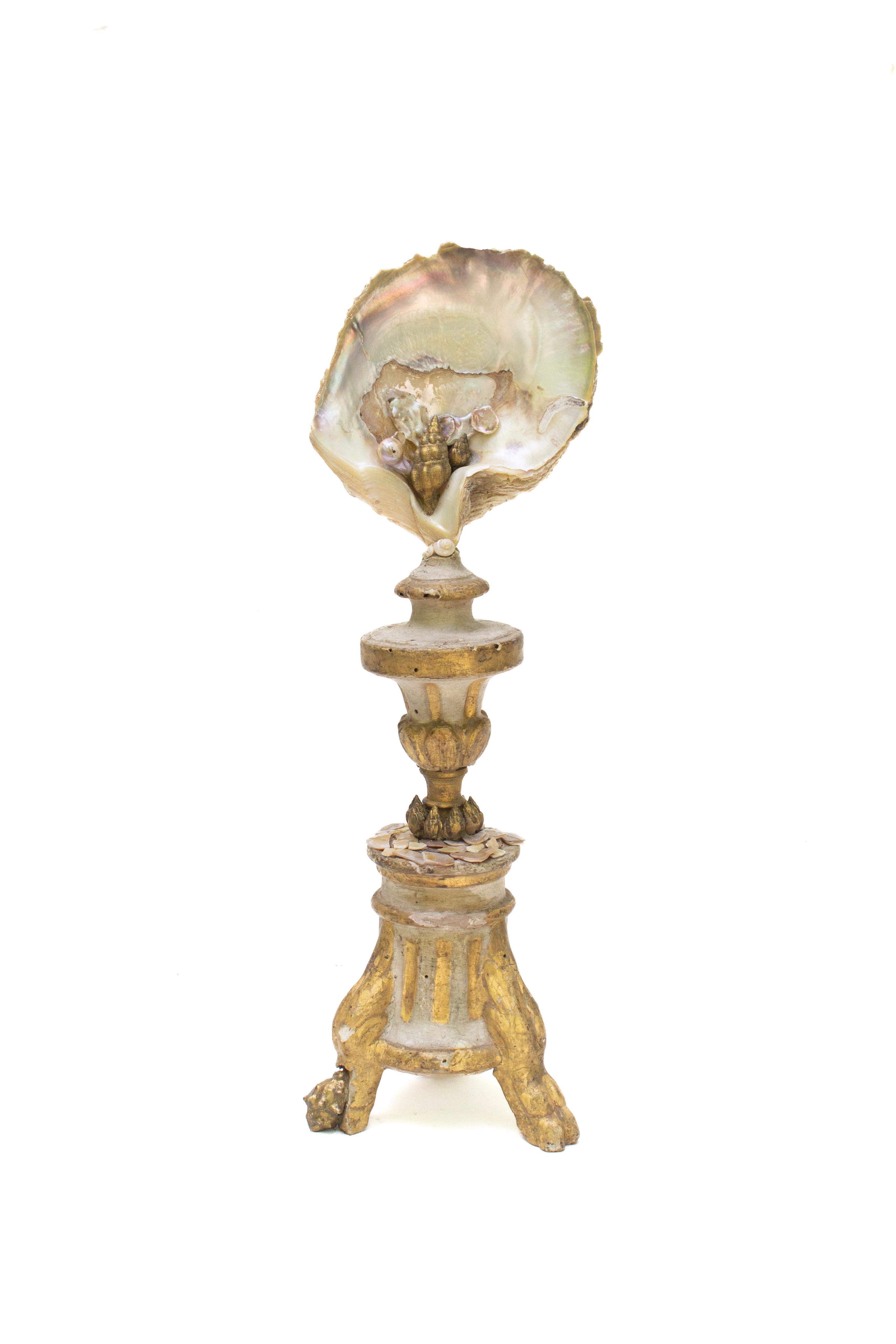 18th century Italian gilded candlestick mounted with a pearlescent oyster shell and adorned with gold leaf shells. 

The 18th century Italian candlestick is originally from a historical church in Liguria, northeast of Italy. This was an altar