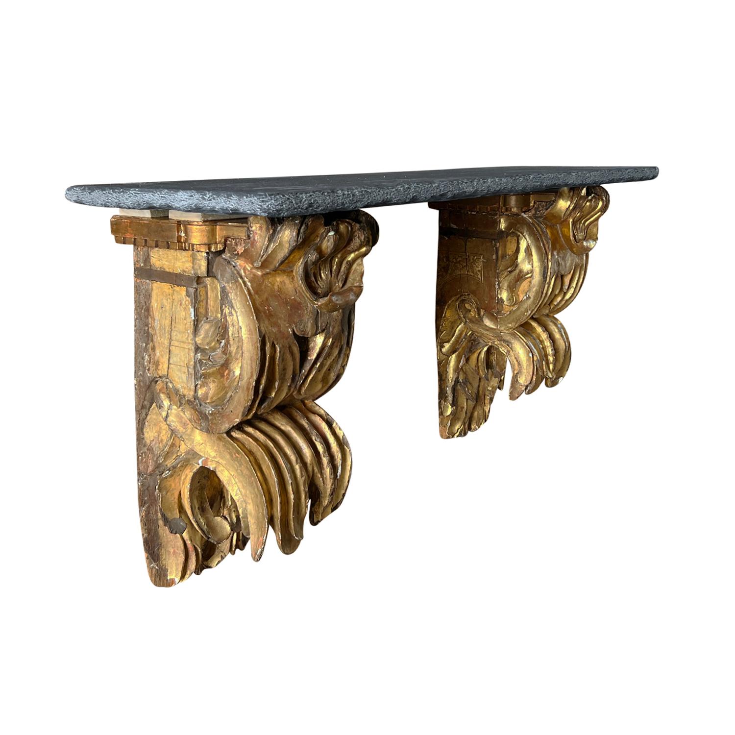An important early 18th Century wall mount console or shelf with antique gilded wall sconces and topped with an aged Belgian Bluestone top, in good condition. The antique pair of sensational late Renaissance/early Baroque sconces show an authentic