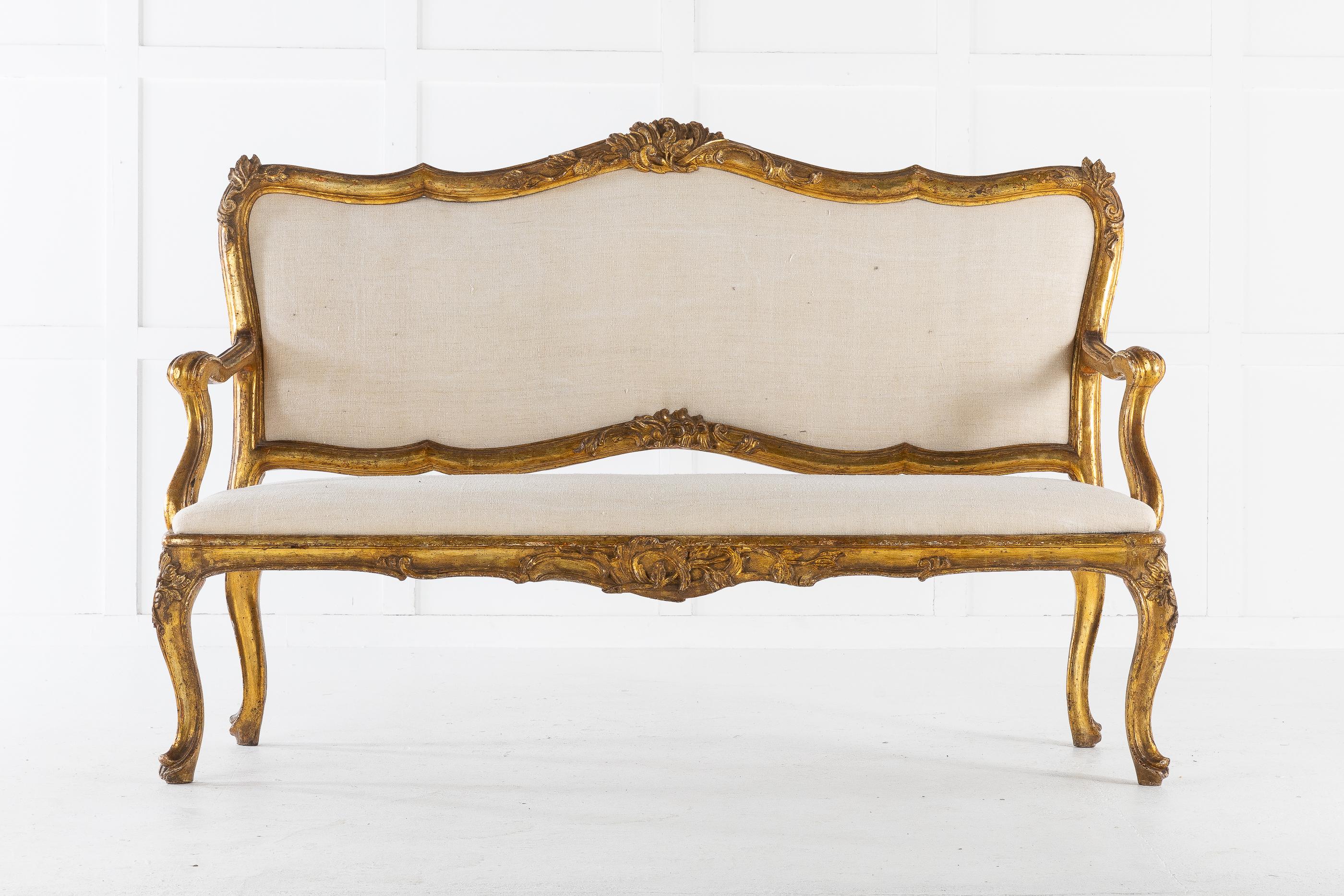 A fine 18th century Italian sofa with nice original aged gilding. Having a shaped back decorated with foliage and carved crest, scrolling armrests on a padded seat supported by cabriole legs.

Upholstery by us in our workshops.
Measures: Seat