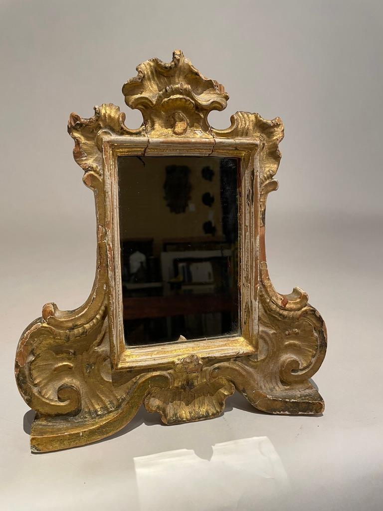 Sweet 18th century Italian carved and gilt wood 'Carte Gloria' now holding a mirror. Carved in the exuberant Rococo period, this wonderful little frame has a lot of personality. Retaining the original gilding, and even the original backing, with the
