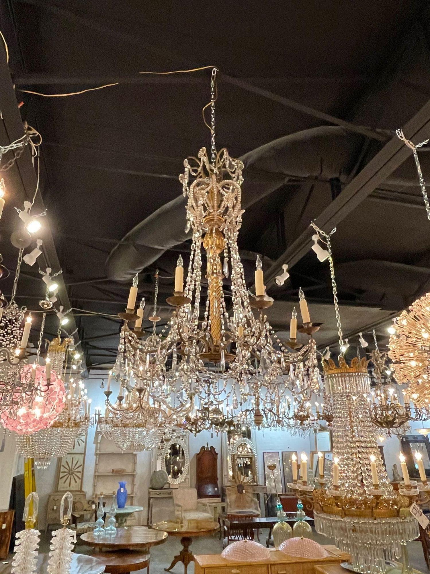 Lovely 18th century Italian giltwood and crystal chandelier with 8 lights from Genoa. A very elegant look on this fixture, featuring beads and draping crystals along with a beautifully carved based.  Outstanding!!