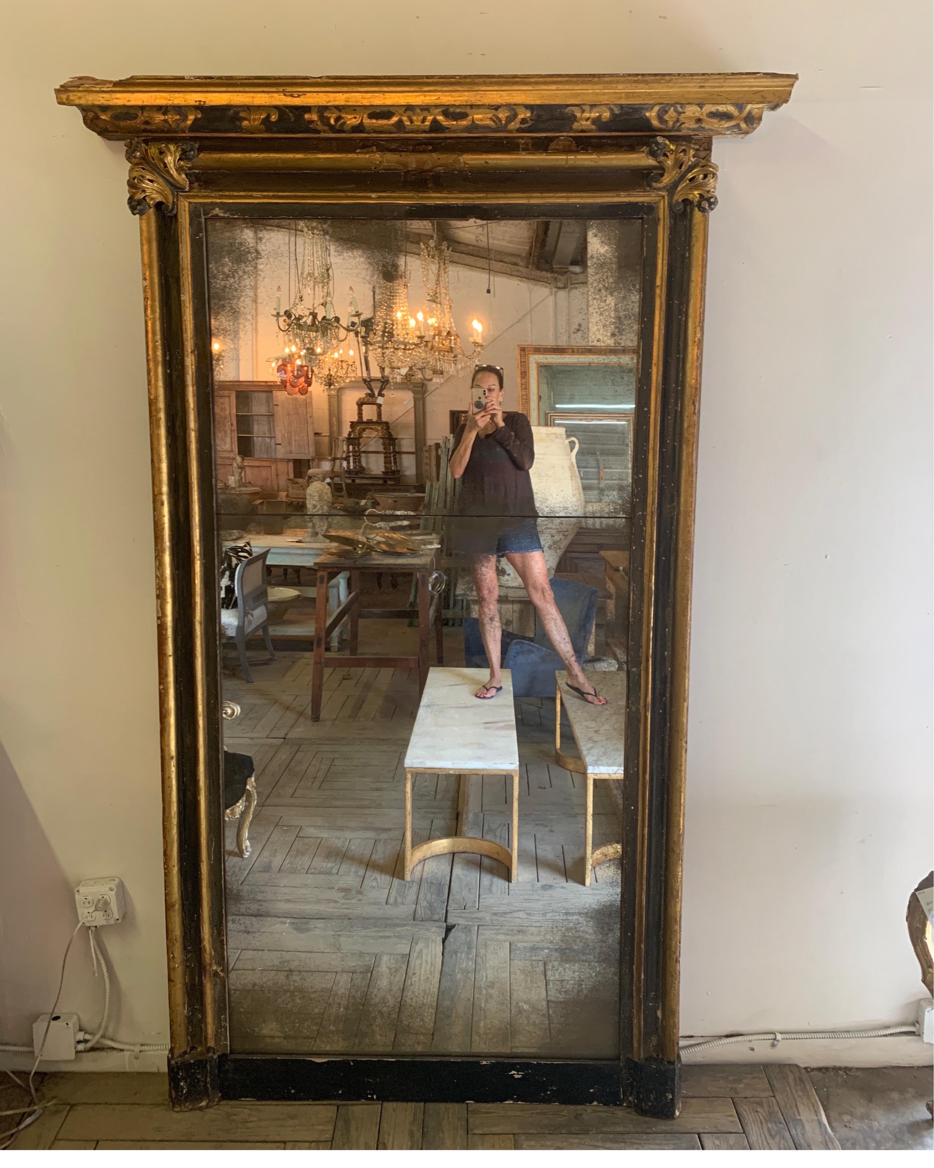 This is a gorgeous floor length mirror from Italy. It is from a Villa in Torino. The mirror is two part aged mirror that has been replaced. The bottom black wood holding the mirror is also a replacement. It’s got incredible wood carving and original