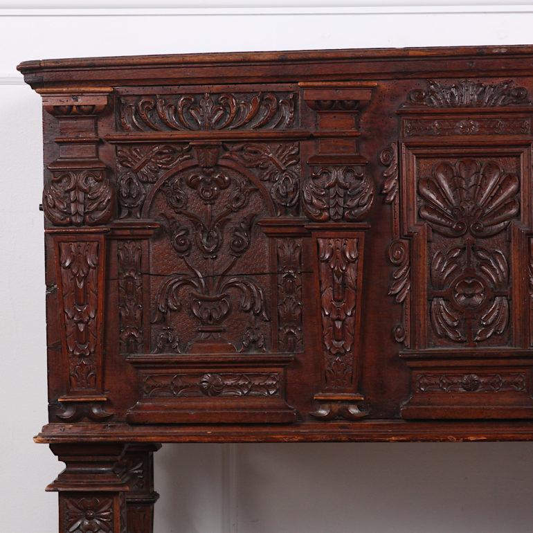 An 18th century Italian cabinet-on-stand with highly-carved Renaissance-revival front panels and doors between carved pilasters, the whole raised on carved square-tapering legs above a lower shelf. The piece was originally a coffer with an opening