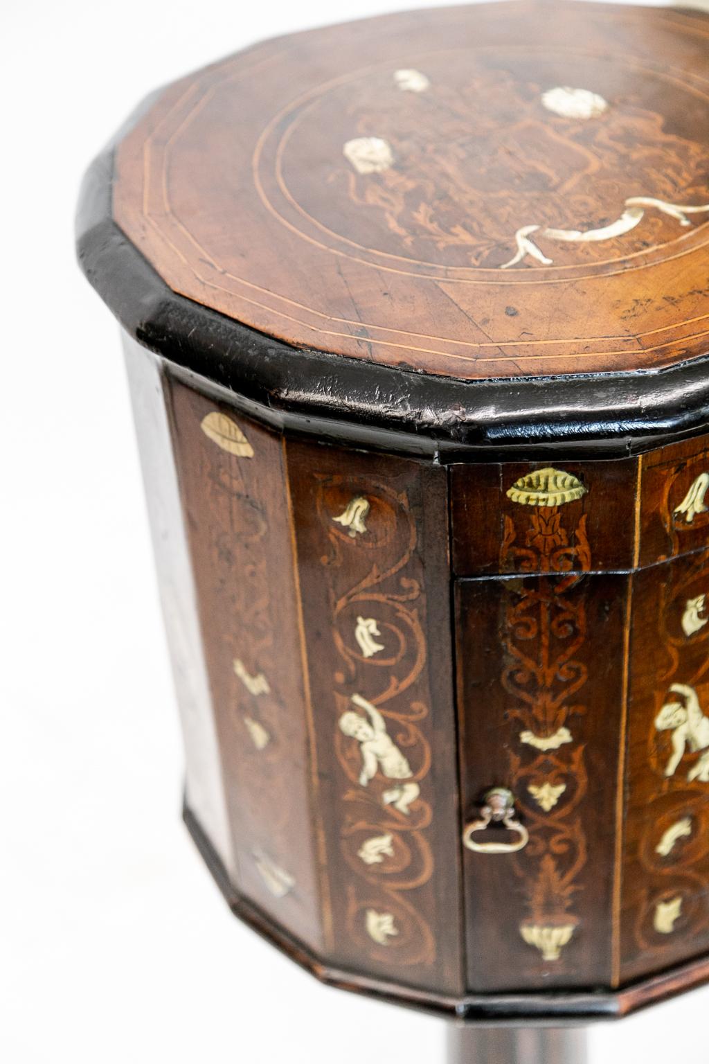 18th century Italian Inlaid Pedestal Commode has one drawer and is made of fruitwood in a hexadecagon shape. The top is inlaid with boxwood double line string inlay. The border has double string inlay surrounding a center medallion which has a crest