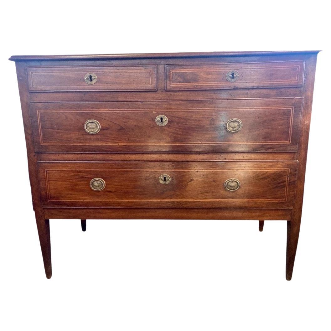 Italian neoclassical commode hand-built in the mid 1700s using walnut. This is an incredibly beautiful commode both because of its overall straight lines, as well as its proportions and color. The crossband inlay is the only decoration present,