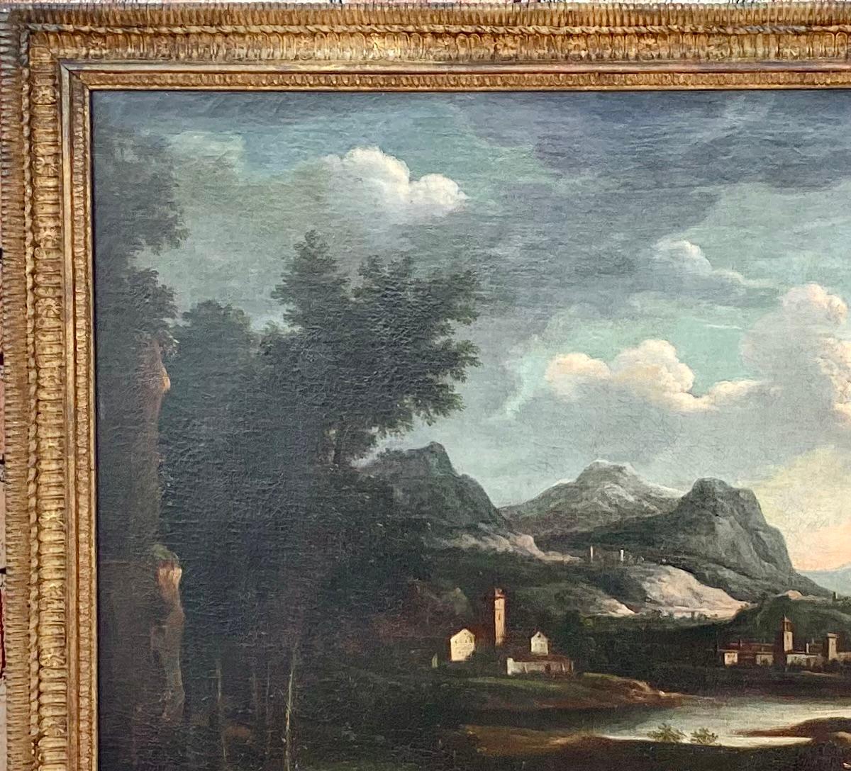 Magnificent 18th century oil on canvas painting of an Italian landscape. Painting features a village, a river with stone bridge and two soldiers on horseback, with mountains in the background. All in muted colors of green, brown, blue and white. 