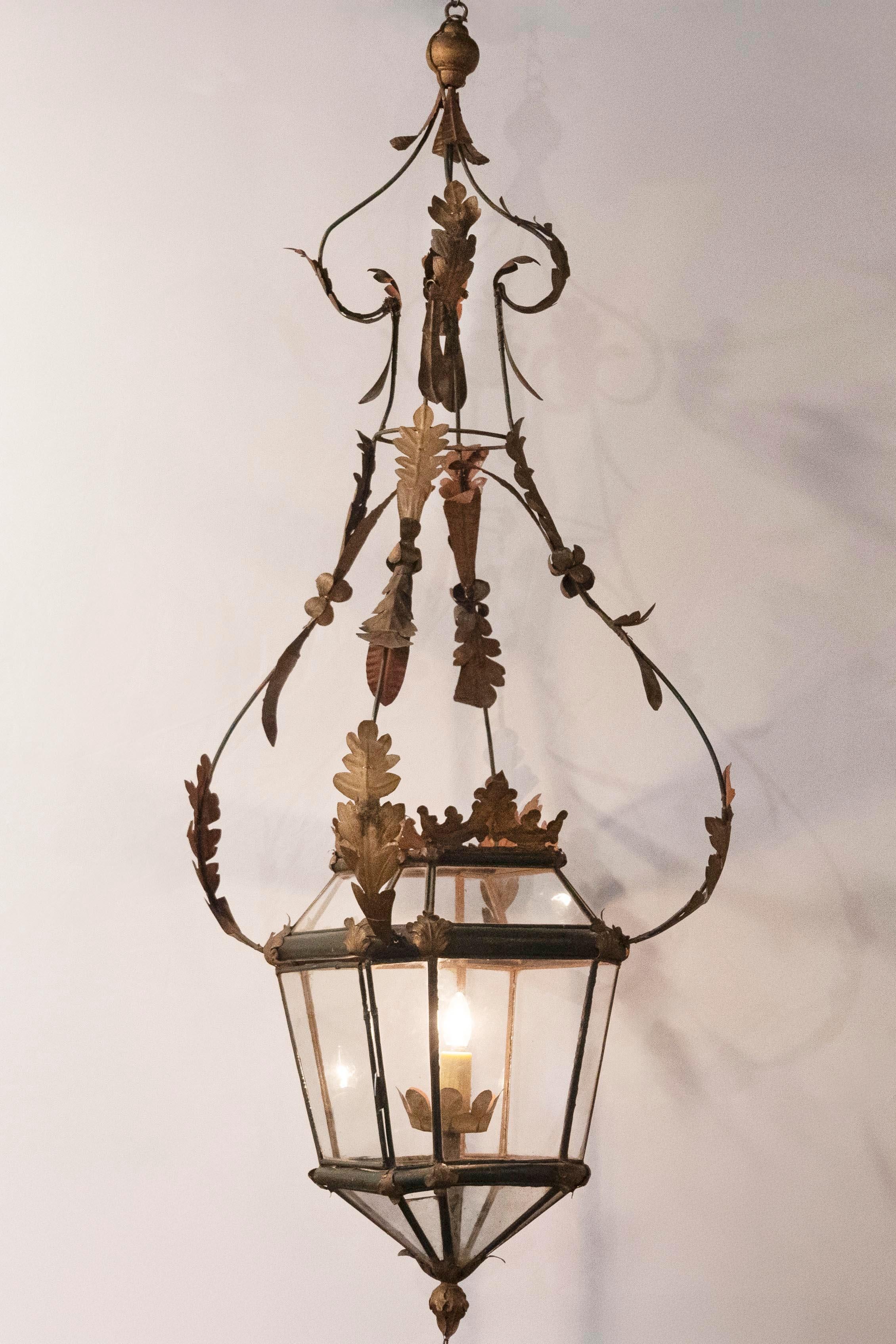 Questa squisita lanterna italiana del XVIII secolo è un capolavoro di artigianato, che unisce eleganza e dettagli intricati. Realizzata a mano in ferro battuto con accenti dorati, questa lanterna a sospensione presenta una cornice allungata e