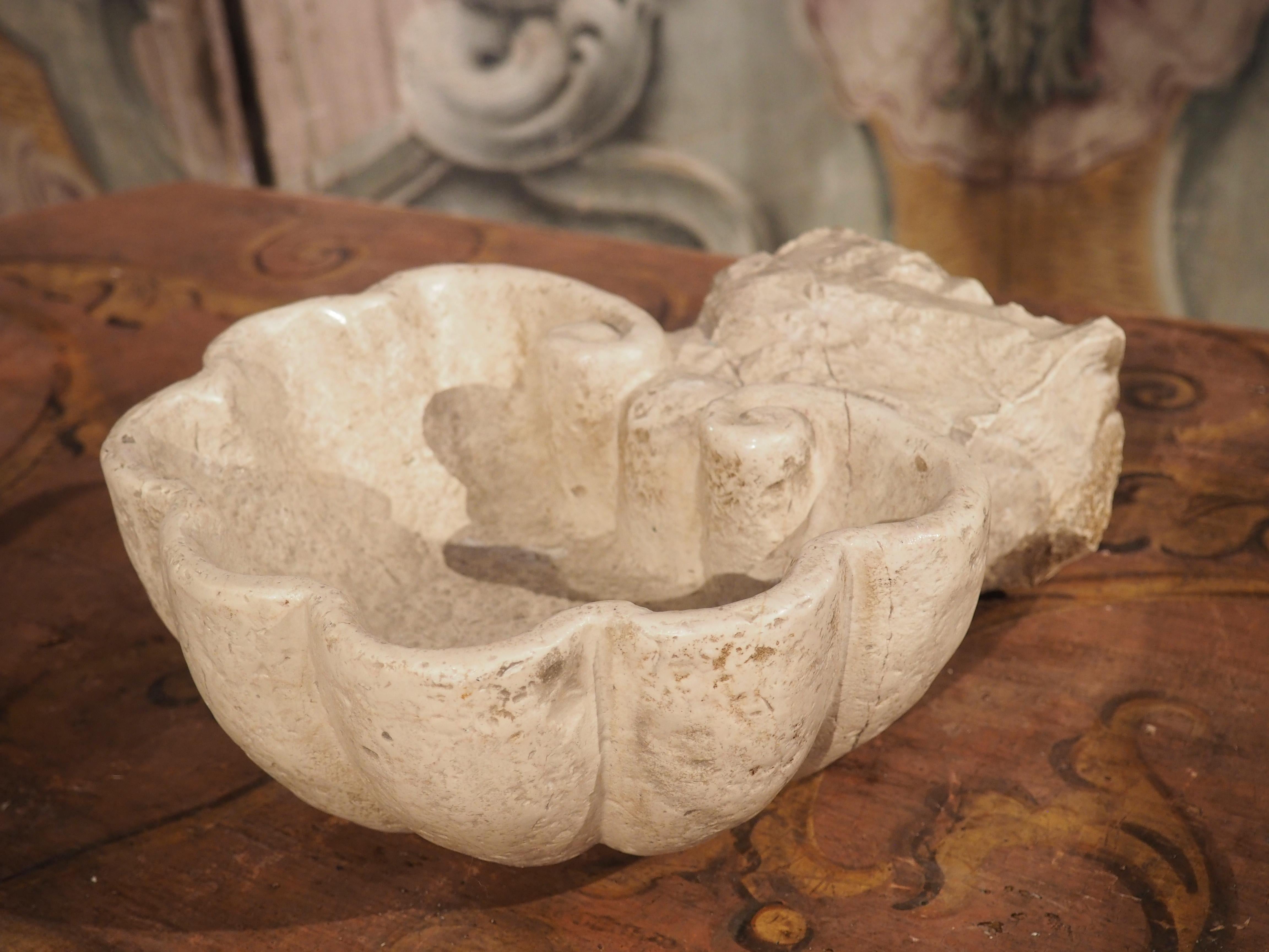 Hand-carved in Italy during the 1800’s, this lobed basin was carved from travertine and painted a beautiful cream color.  Originally, it would have been made as a holy water stoup for a private chapel, affixed directly into the wall.  The thick,