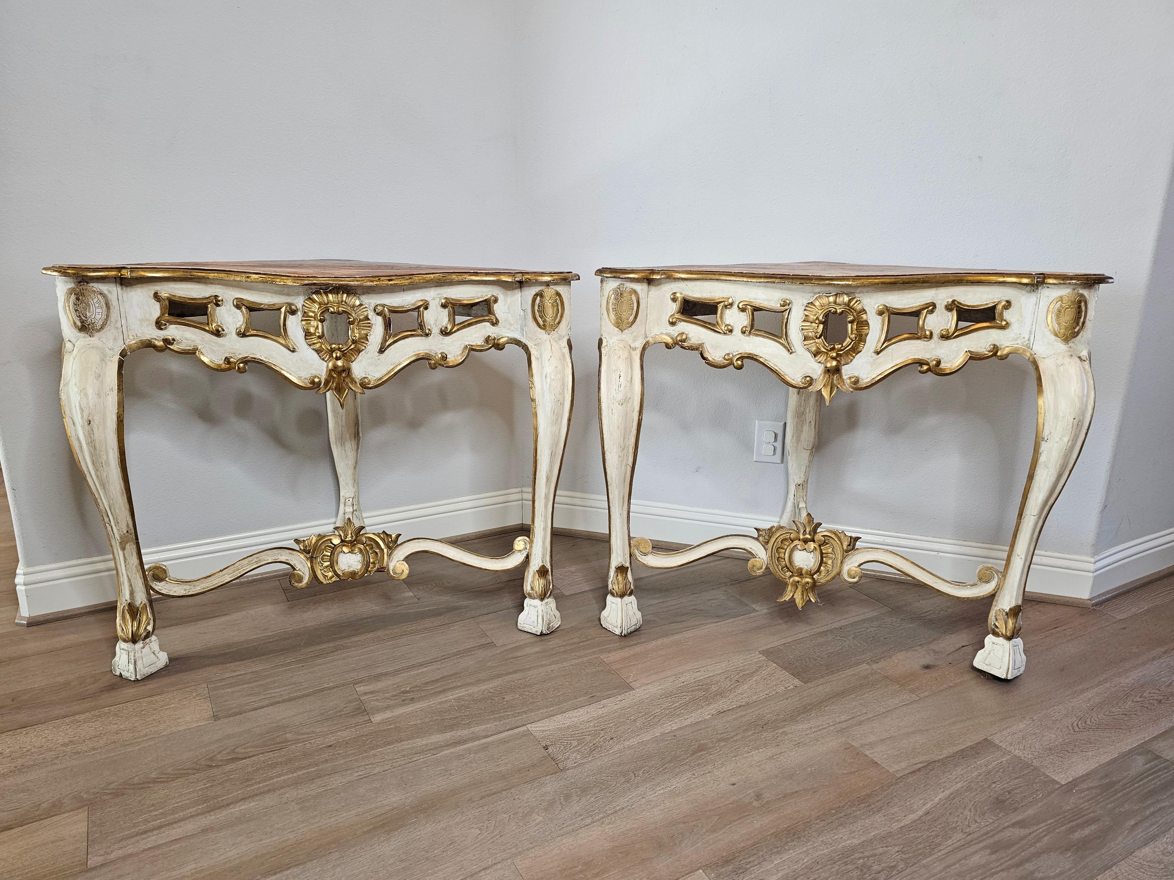 A stunning pair of large antique Italian Baroque carved faux marble painted parcel gilt corner console tables. circa 1740

Hand-crafted in Italy in the 18th century, styled in luxurious period Louis XV (1715-1774) taste, featuring a triangular