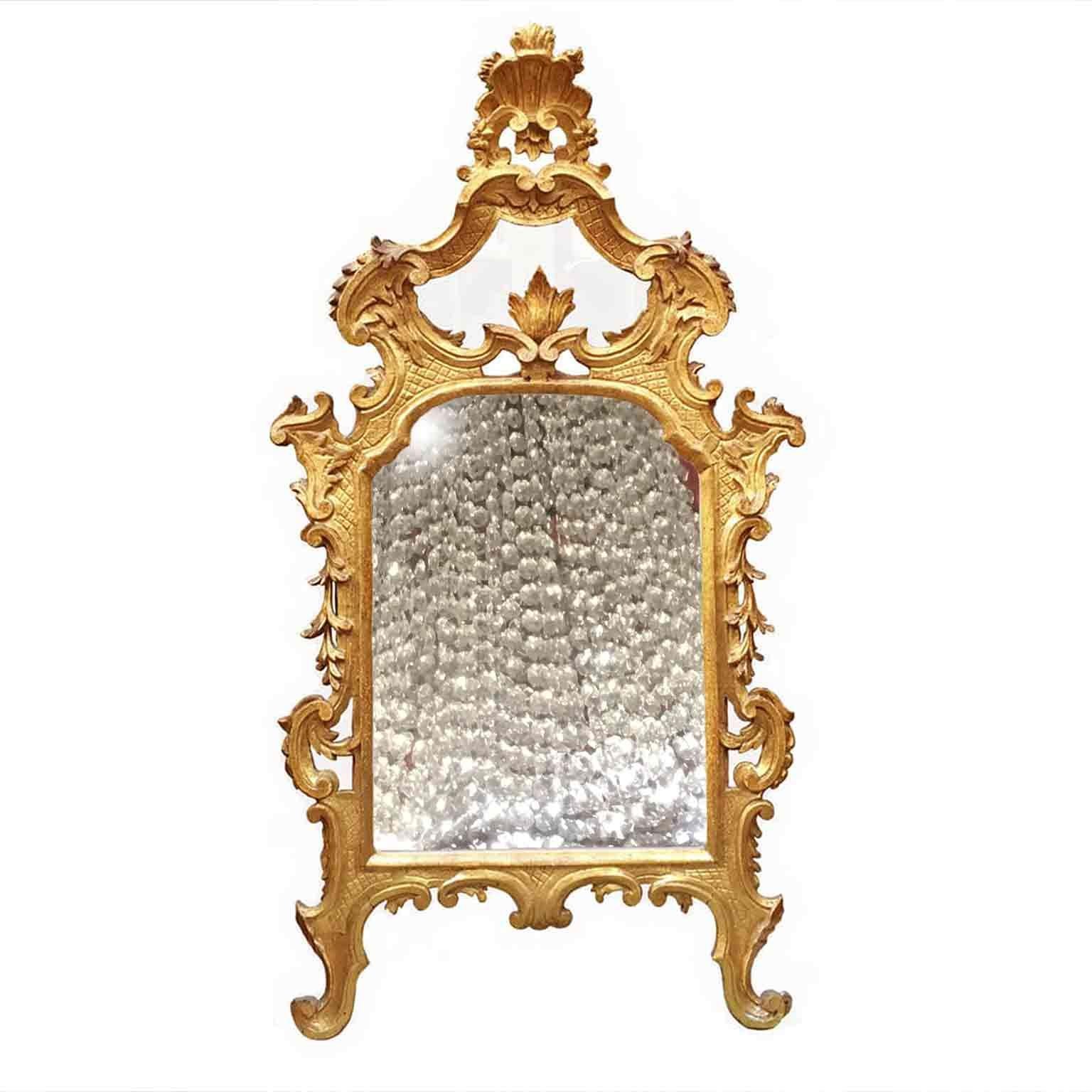 An Italian Louis XV carved and gilt wood mirror dating back to the third quarter of 18th century. Of Tuscan origin, this antique mirror it is realized in Cembran pinewood and comes from the furnishing of a villa in Lucca and it is in overall good