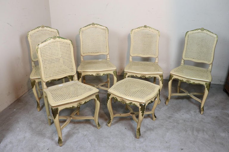 Elegant antique Italian Louis XV living room set 18th century period with classic cabriolet legs. The living room is composed of 1 sofa 5 chairs and 1 stool. Elegant finish in cane on back and seat. The living room is lacquered in cream shades.