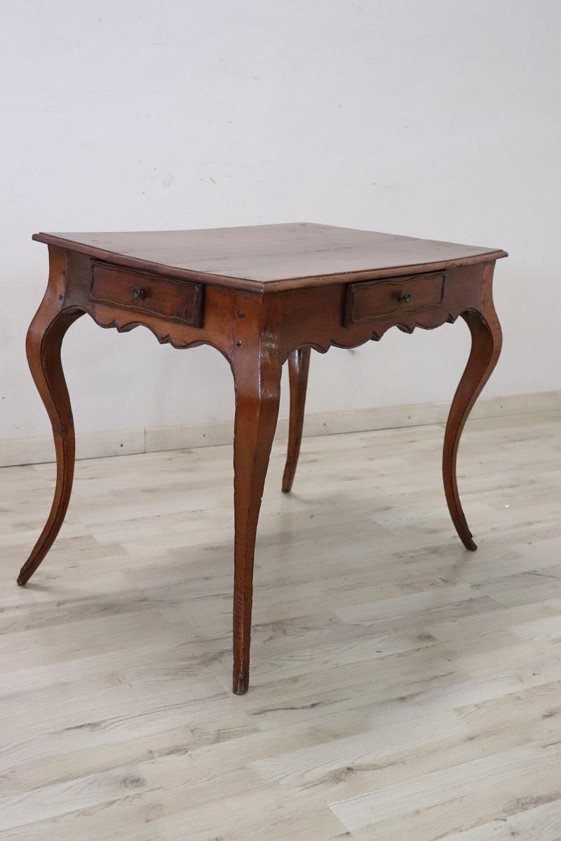 Cette table italienne ancienne de style Louis XV, datant du milieu du XVIIIe siècle, est un excellent exemple de l'artisanat méticuleux et du design sophistiqué qui caractérisent les meubles de cette période. Fabriquée en bois de cerisier massif,