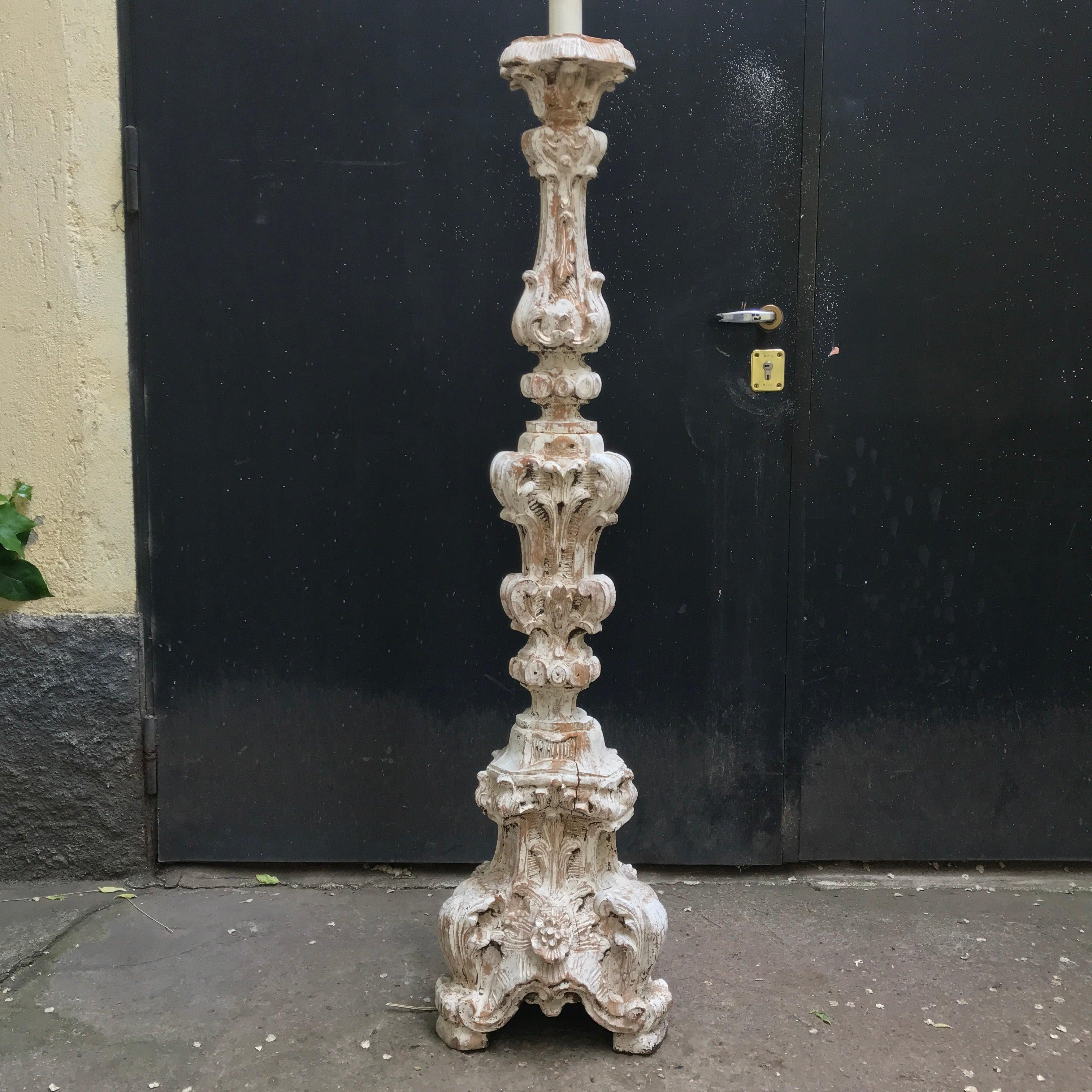 Italian Florentine hand carved wood torchère as floor lamp, a tall solid cembran pinewood pricket carved on three sides, with a deep acanthus leaf and flowers carving, resting on tripod base, dating back to 19th century but inspired to 18th century