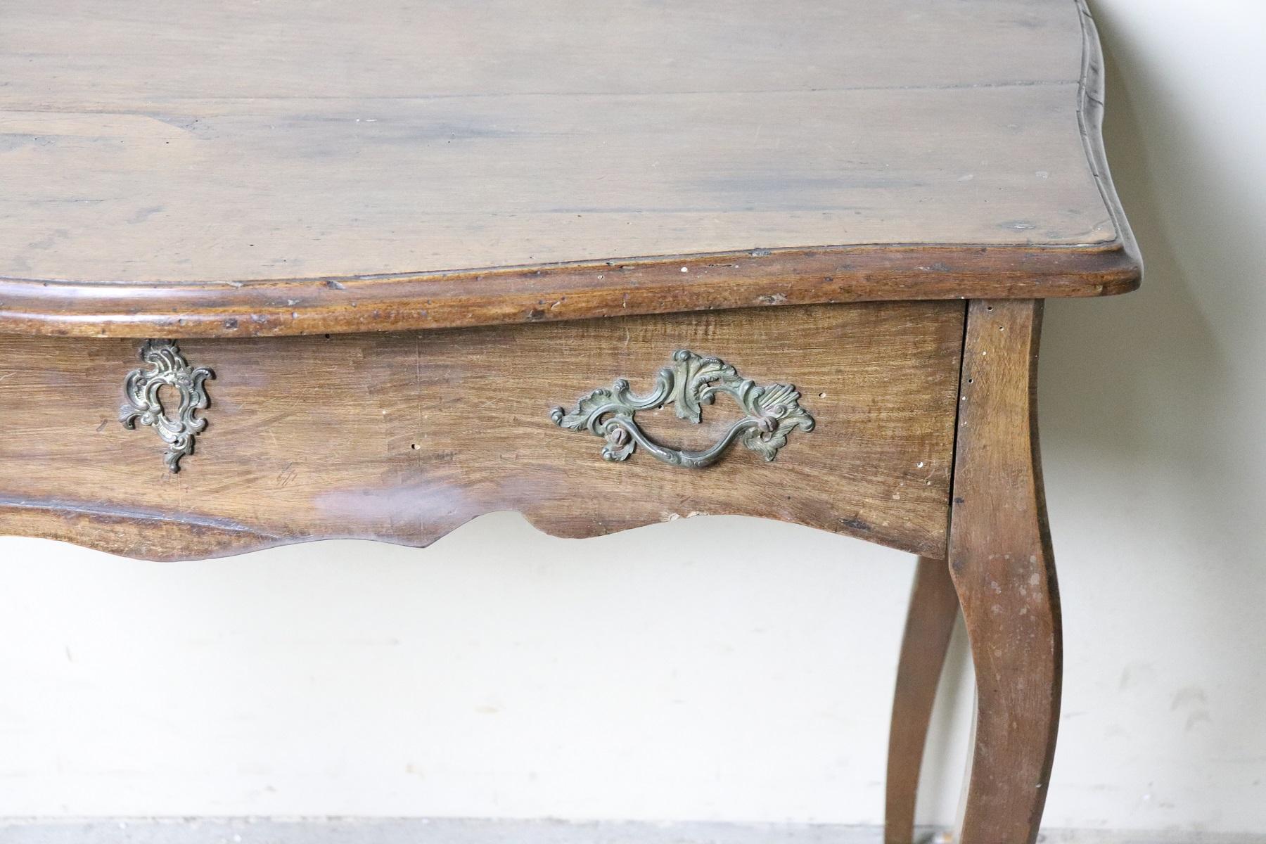 Elegant and essential antique Italian writing desk. 18th century Louis XV period with classic cabriolet legs. On the front it has 1 useful drawers. Rare and precious walnut. The back of the desk is rough because it is designed to be placed against