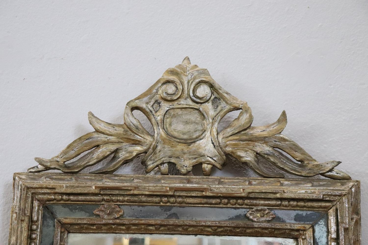 Beautiful elegant antique Louis XVI wall mirror 1780s. Hand carved wood with finely and richly swirls and curls. Refinement decorated in mecca gilding. In good antique conditions. The mecca gilding has a beautiful antique patina. The mirror is