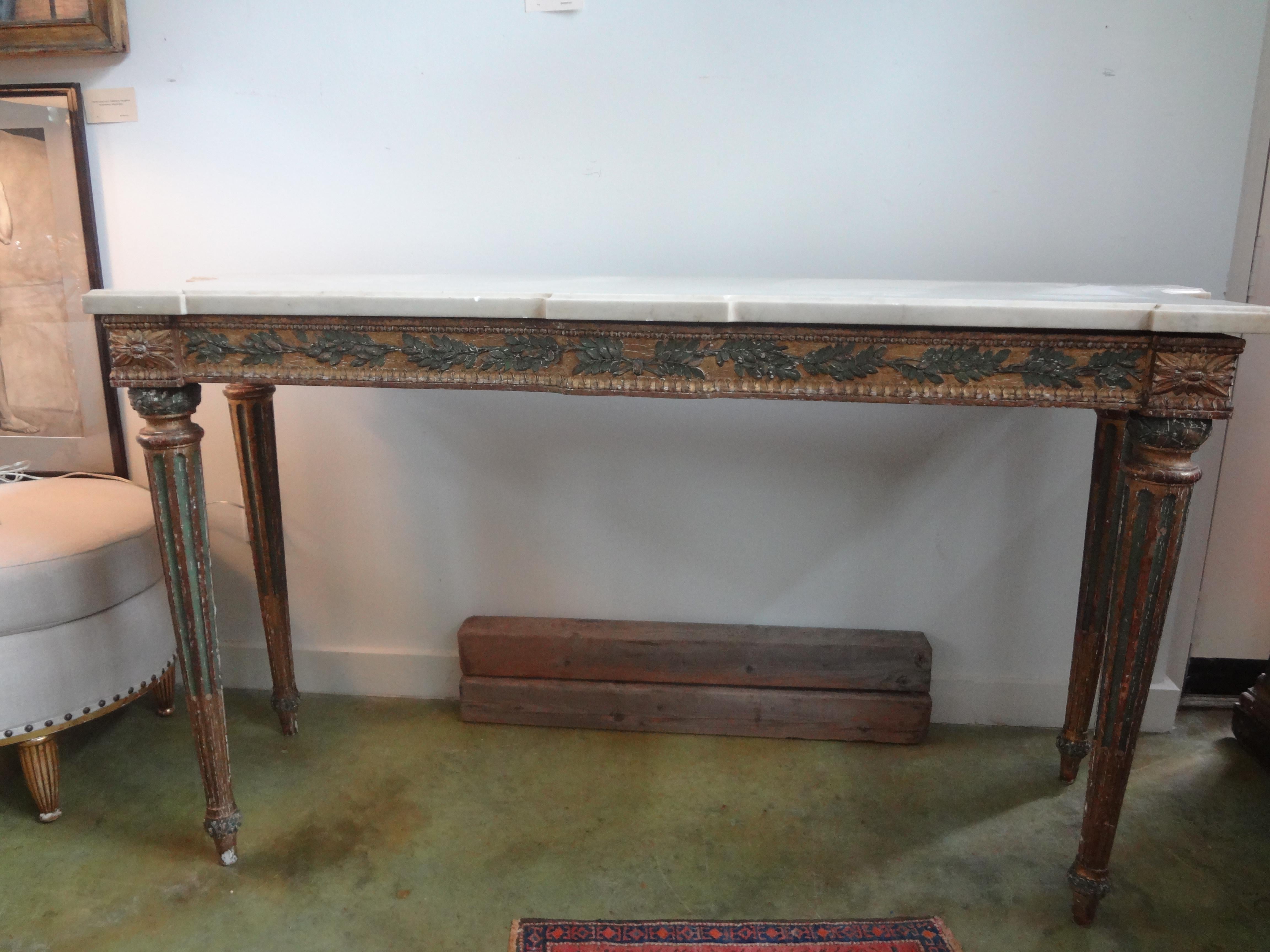 18th century Italian Louis XVI console table, painted and parcel gilt.  This stunning freestanding antique Italian console table has a raised leaf design on the apron, tapered legs and a Carrara marble top.