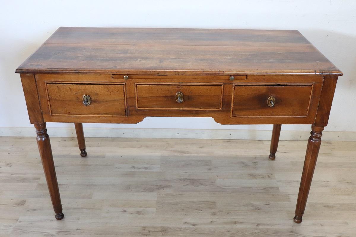 Elegant antique Italian writing desk of the period Louis XVI, 18th century. Rare and precious solid walnut wood. Comfortable size for a practical use. The desk has elegant turned legs. In the lower part three drawers and in the upper part two