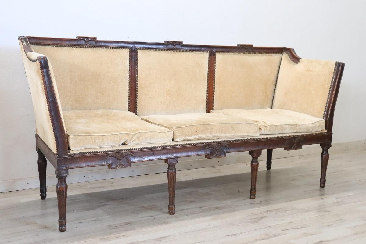 Canapé italien ancien d'époque Louis XVI. Réalisé en bois de noyer fin et revêtement en velours, caractérisé par une ligne simple et essentielle mais très élégante. Nous recommandons de remplacer le velours en raison de la présence de taches et de
