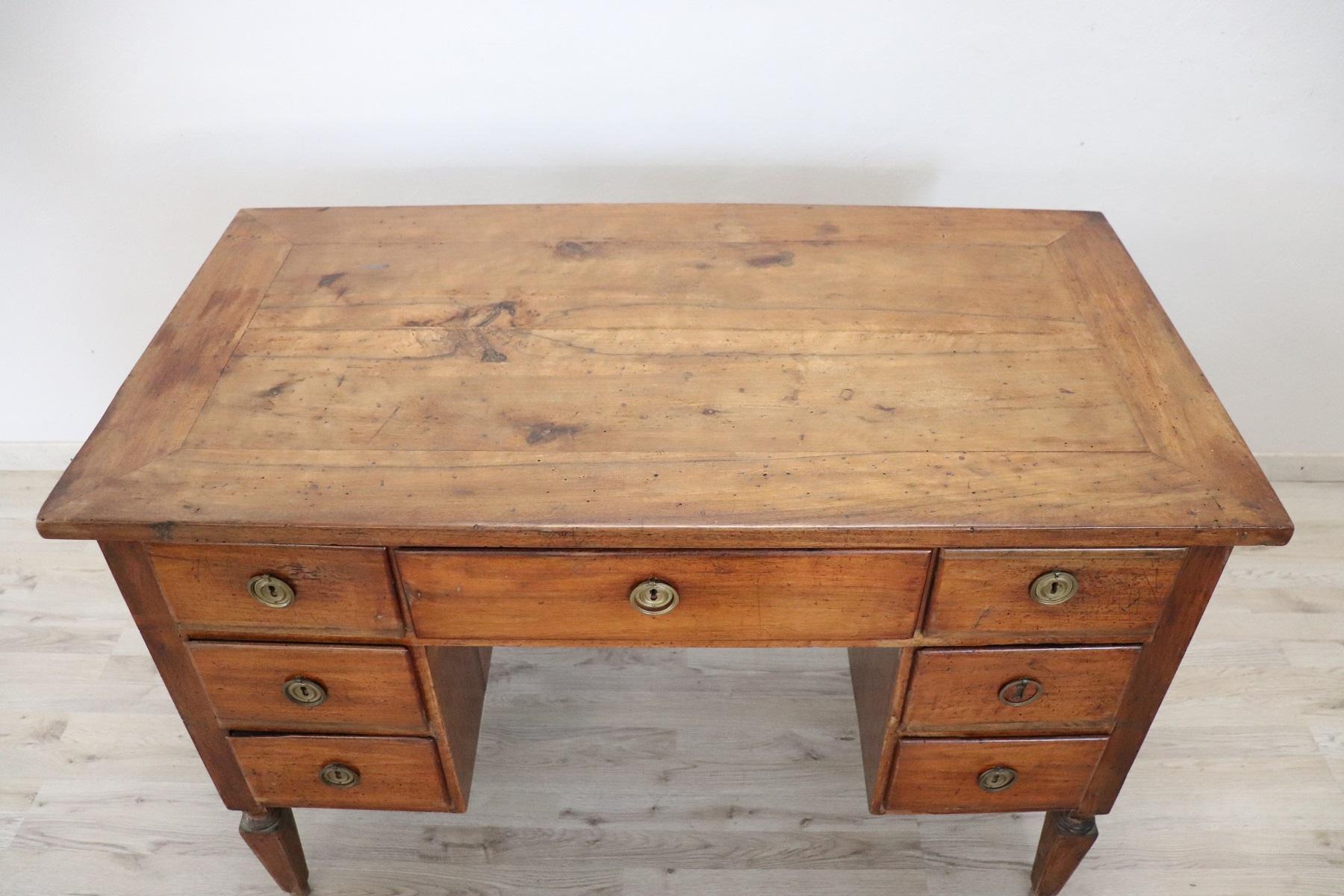 Elegant antique Italian Louis XVI writing desk. The desk is made of walnut wood. Simple essential line with solid straight legs. Plenty of space for your writing needs and seven comfortable large drawers on the front. Finished on each side so it is