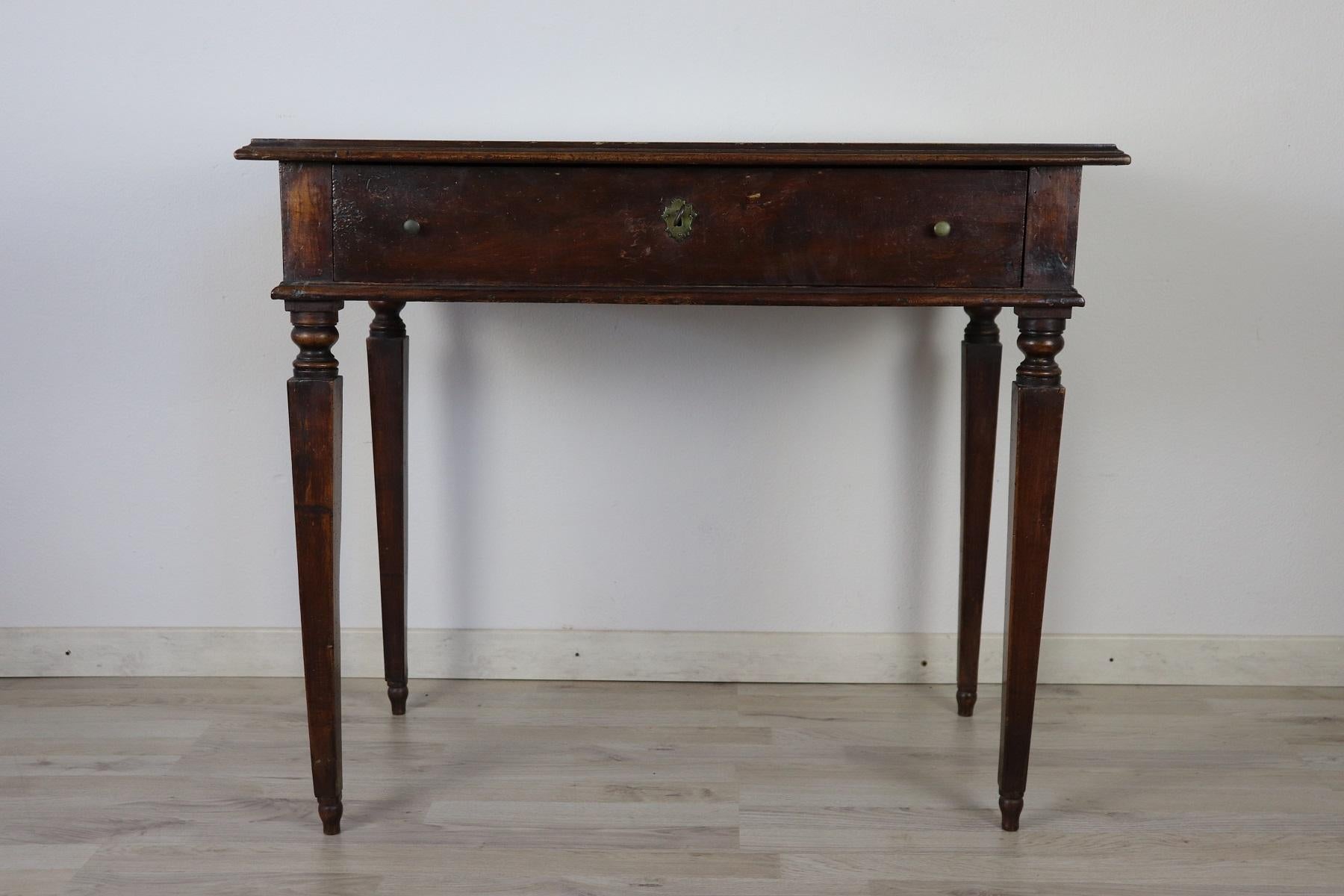 Elegant and essential antique Italian writing desk. Louis XVI period with Classic spiked legs. Present one drawer on the front. Locks and nails of the 19th century. Beautiful walnut wood.