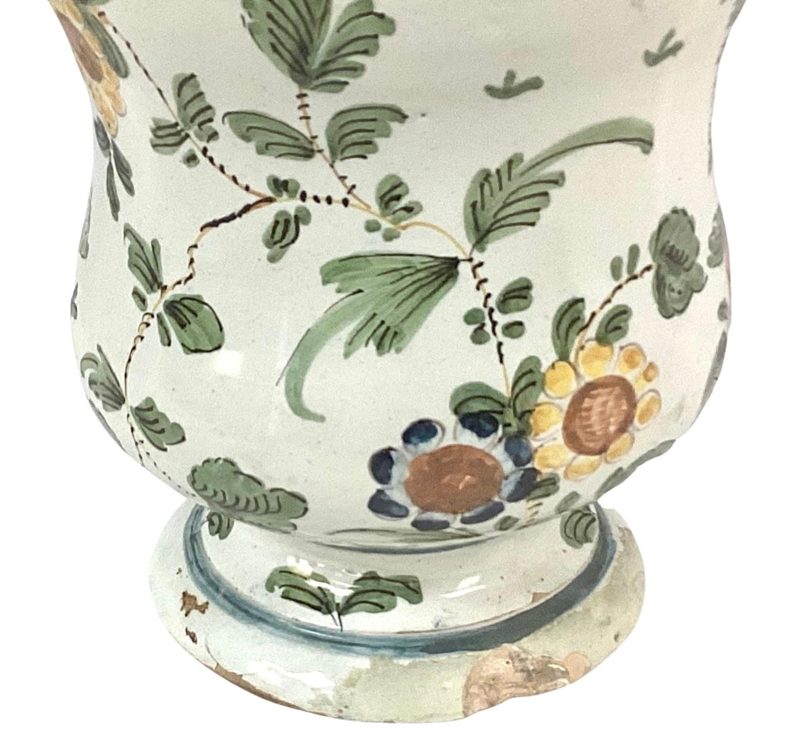 An impressive 18th century polychrome decorated drug jar or 'Albarello'.

The Albarello is of a typical waisted shape, and is decorated profusely in polychrome. The body of the jar is decorated with brightly colored polychrome of yellow, green and