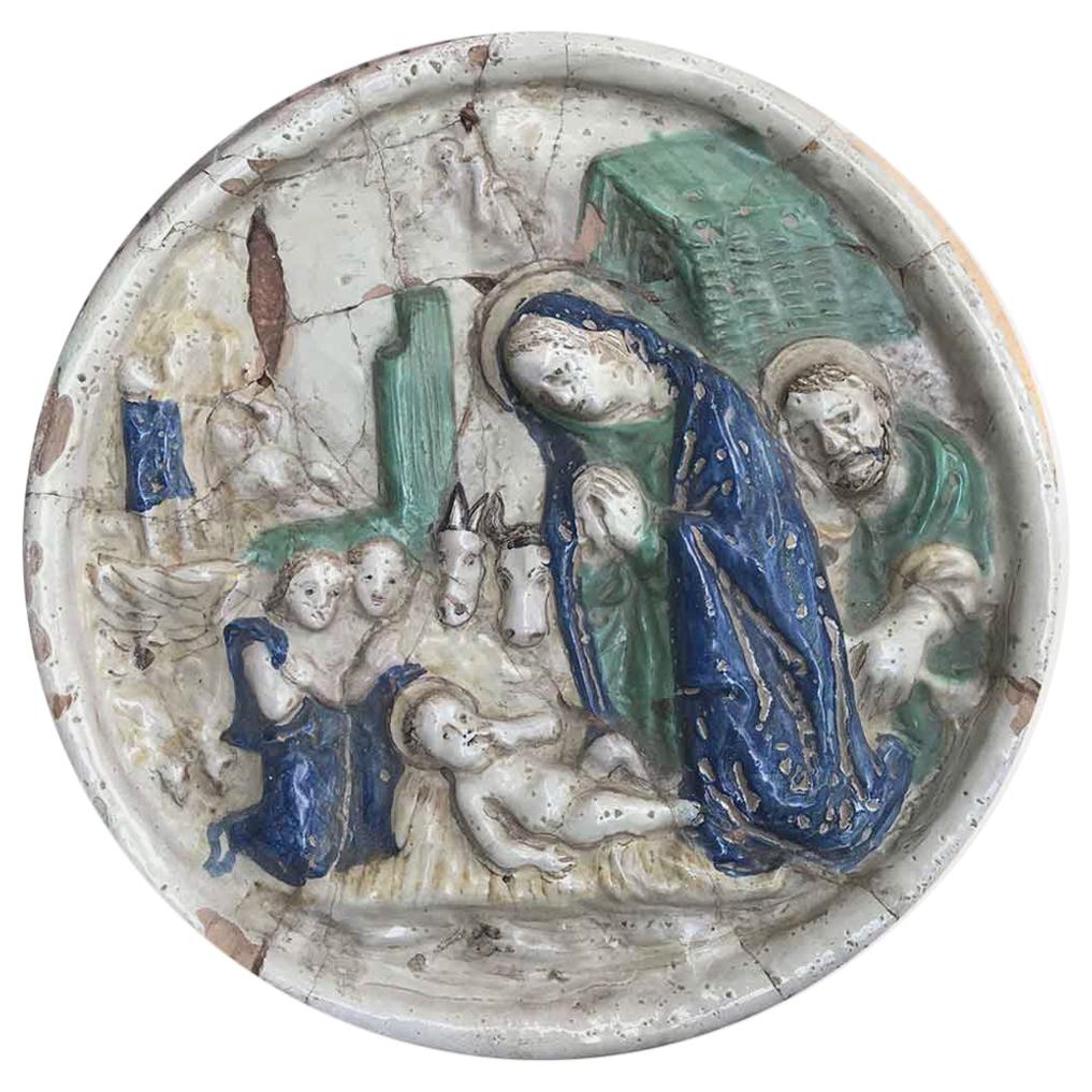 A 18th century Italian Maiolica Nativity,  an hand-made circular relief devotional plaque in polychrome majolica depicting a  Nativity scene,  dating back to the early 18th century, hand-made in Umbria, a central Italian region and measuring almost