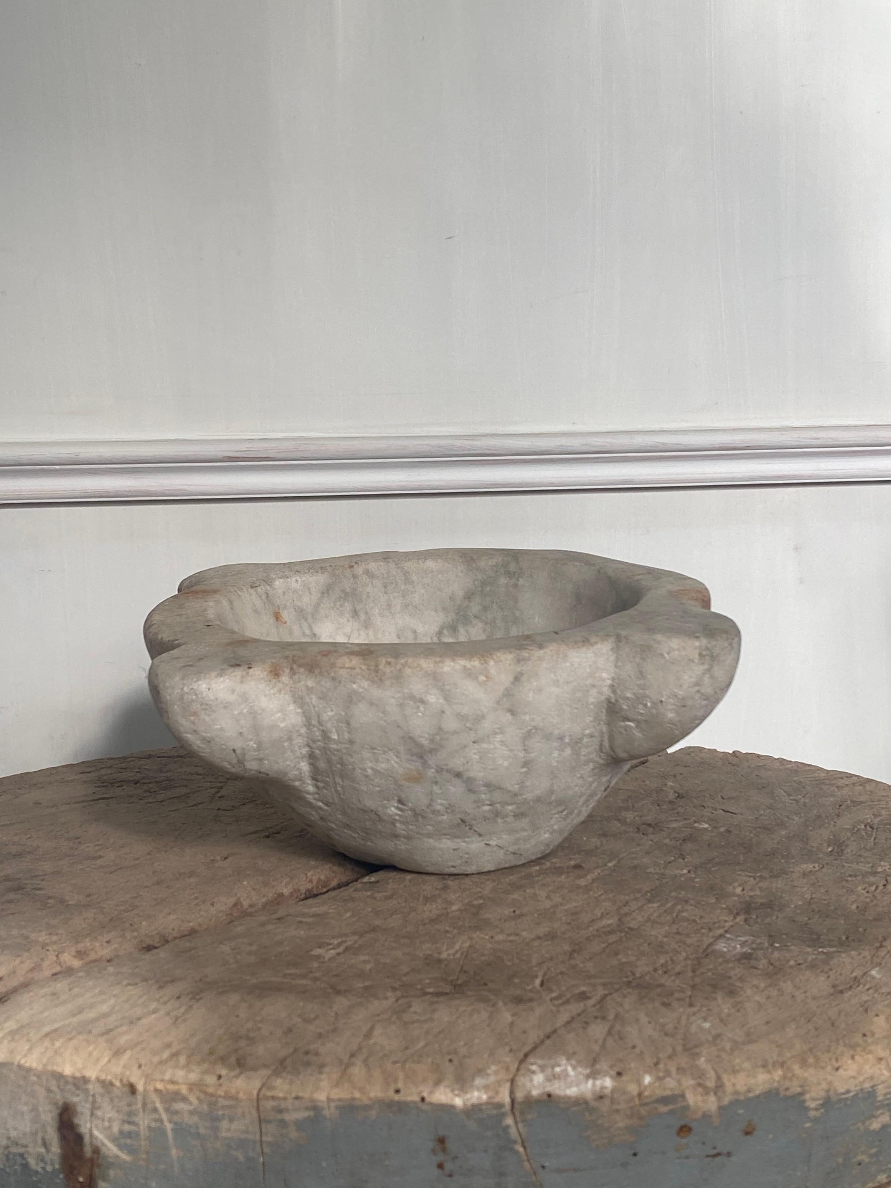 18th century pharmacist's mortar with an enormous display of use. The mortar is even obliquely worn by age and use.
Beautiful Carrara marble with a lot of patina.
All ears complete. 
Exceptional item in both kitchen and living space.

We ship