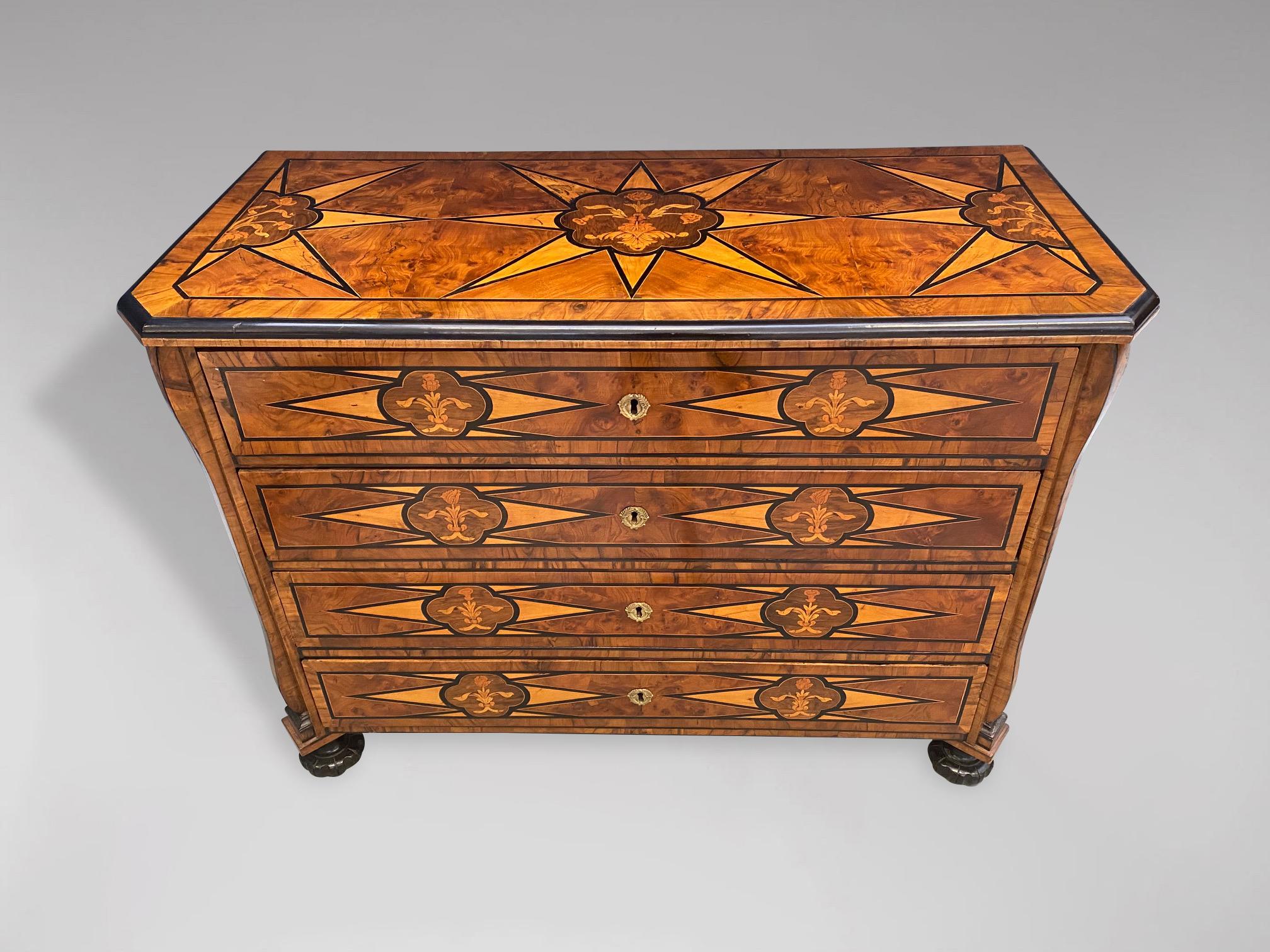 A stunning 18th century marquetry chest of drawers or commode with several different wood inlays and marquetry. Rectangular inlaid moulded top above 4 long graduated drawers. All standing on reeded bun feet. All drawers beautifully lined with