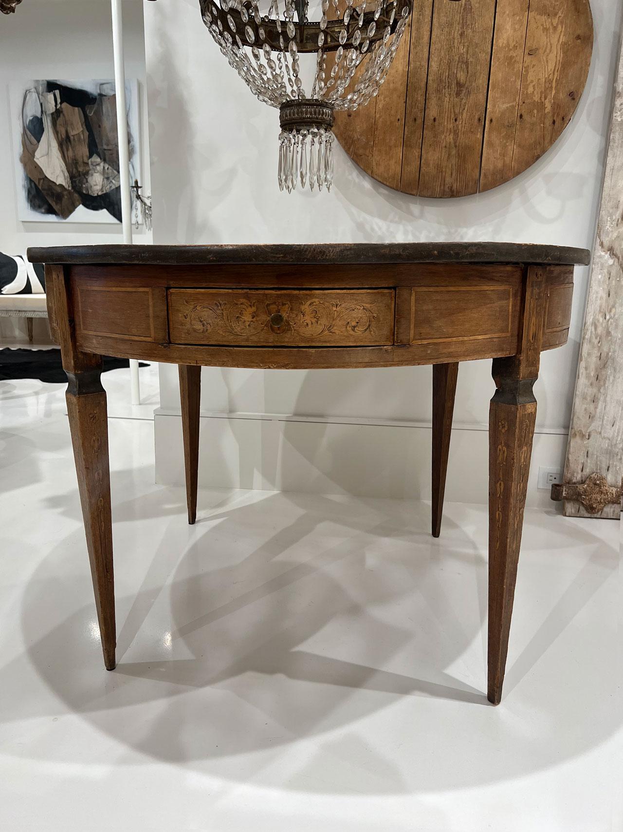 The perfect table for an entry foyer or alcove. There are four drawers all around that should be left accessible as they are a good size for stashing small items like keys and pens. The top is done in an intricate wood inlay or marquetry. The table