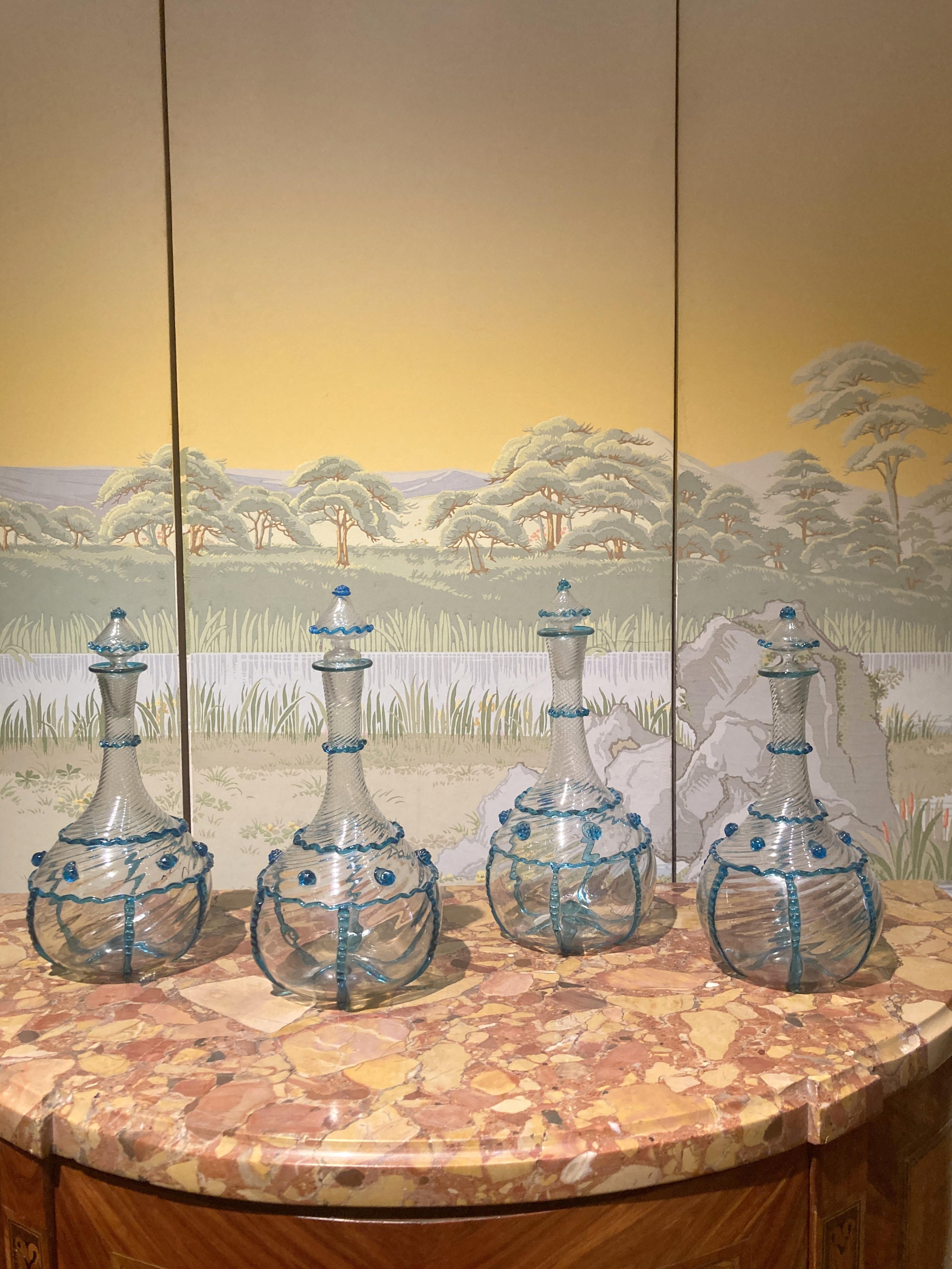 Dieses wunderbare antike, mundgeblasene Klarglas-Set aus Murano aus dem späten 18. Jahrhundert (ca. 1780), das an die Form eines Flaschengeistes erinnert, ist aus sehr dünnem und durchsichtigem Glas hergestellt. In gewundener und gedrehter Form,