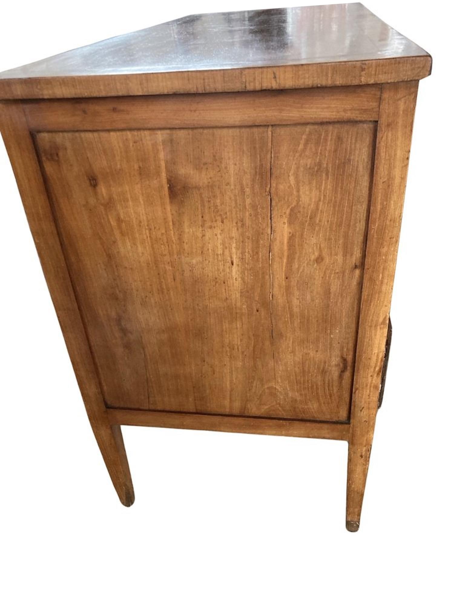 Neoclassical chest of drawers hand-made in Italy using walnut. This piece shows the typical italian neoclassical lines, with a flat front with inset drawers, straight panel sides framed in flat molding and long tapered legs. The chest of drawers