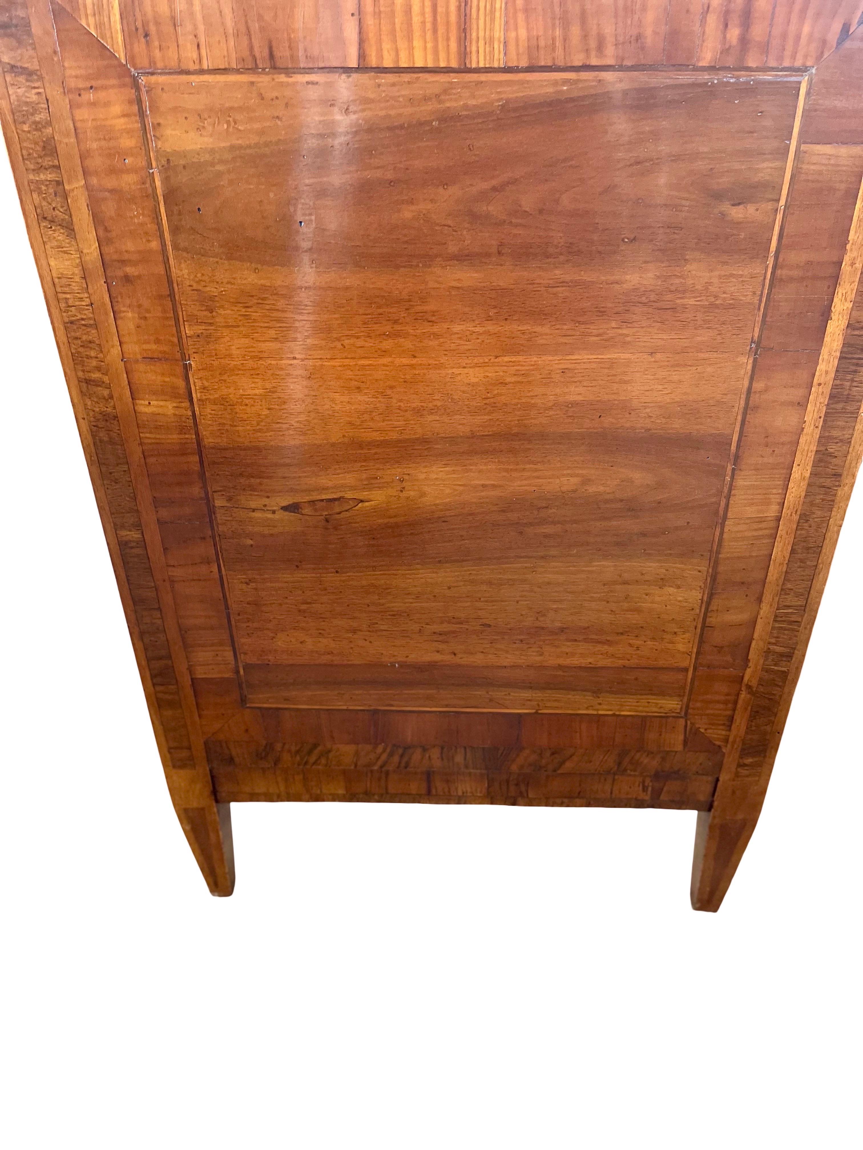 Neoclassical commode hand-made in Italy in the late 1700s using walnut and decorated with walnut veneer. This is an absolutely stunning chest of drawers both because of its lines and color and because of the perfect placement of veneer of different